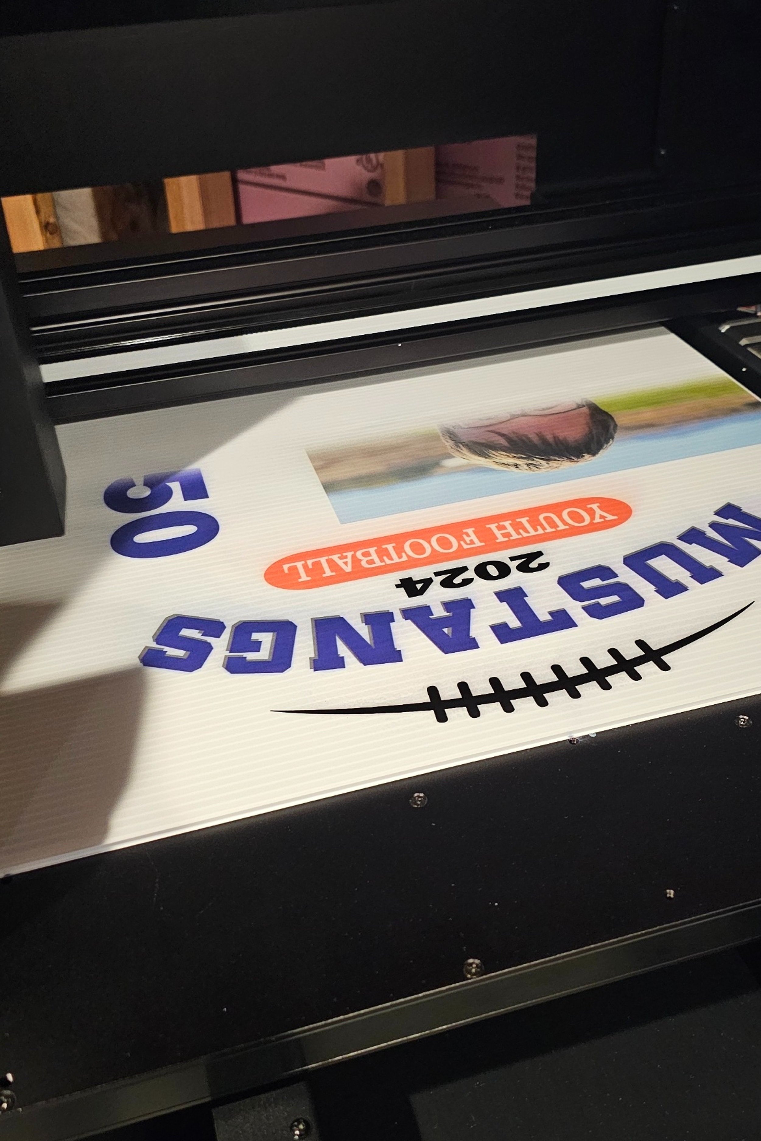 A curated lawn yard sign being UV Printed for a local, youth sports team to put in the student football athlete's yard to celebrate during Homecoming Week for their High School celebration.