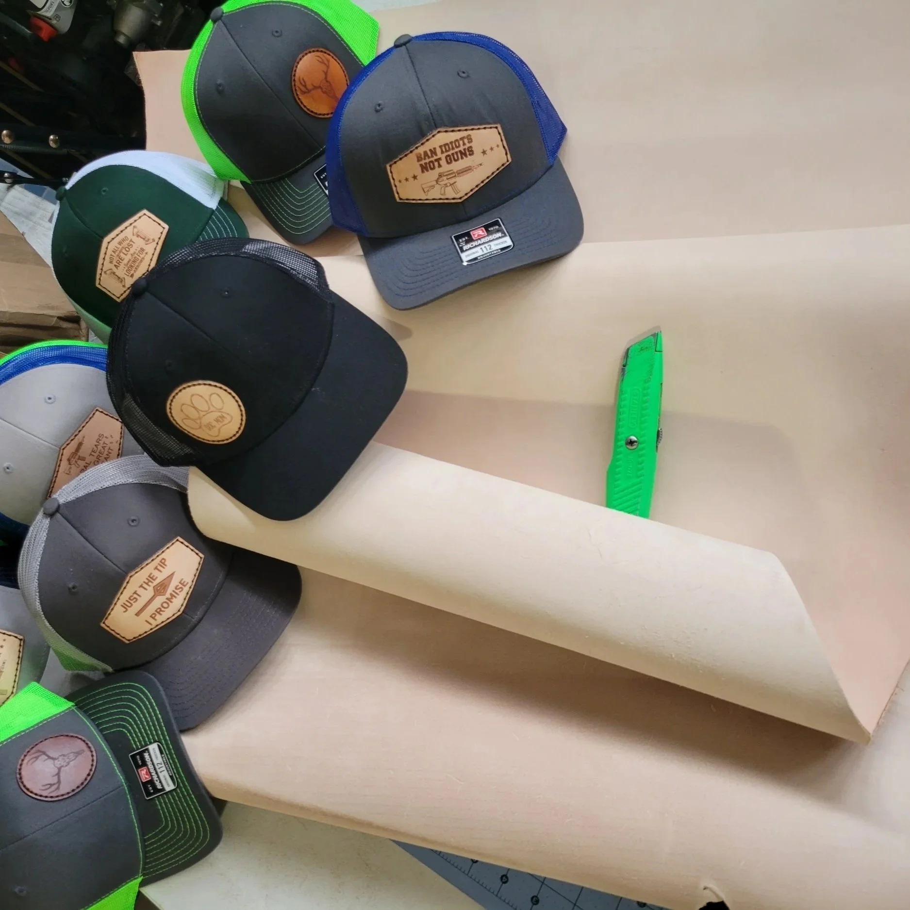 Roll of cowhide unprocess with finished hats that have sewn on leather patches.