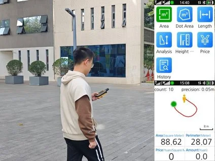 Construction worker with yellow hard hat and orange safety vest operating surveying equipment outdoors.