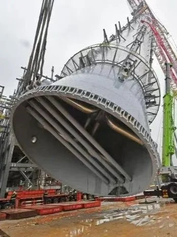 Close-up view of a large industrial drilling or boring machine on a construction site, with scaffolding and safety barriers around it.