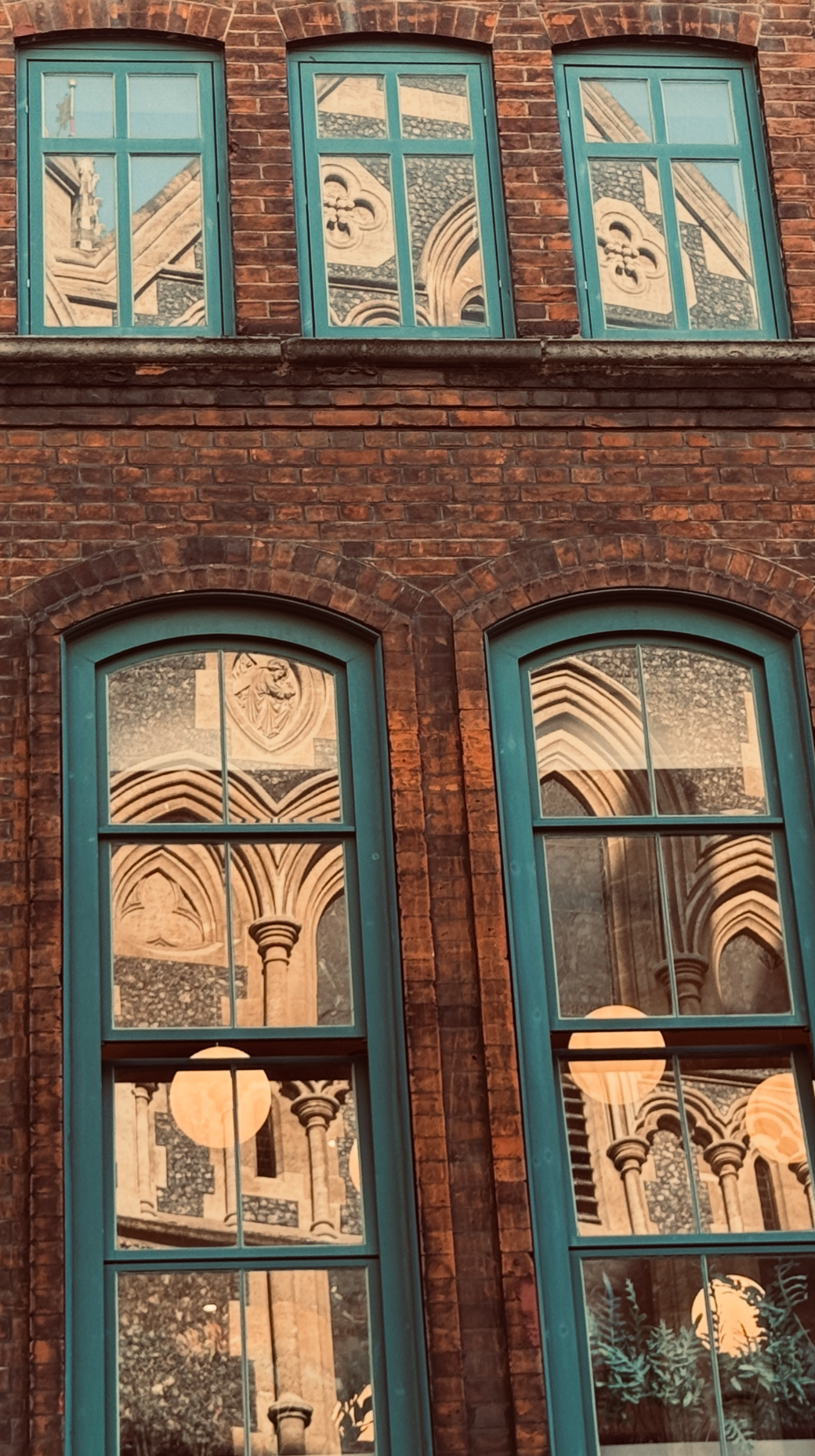 Reflection of historic church architecture and columns in the building's windows.