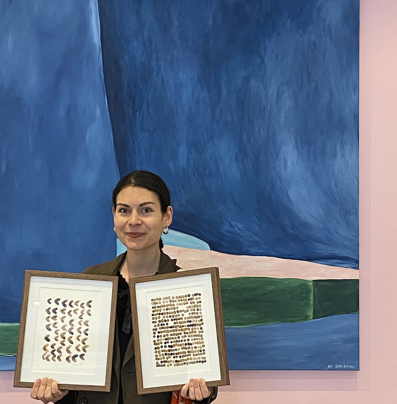 Photo de Lola Mathé avec ses œuvres "Amours" et "Bulles" devant une toile de Sara Odman, à la galerie Esther & Paul (juin 2024)