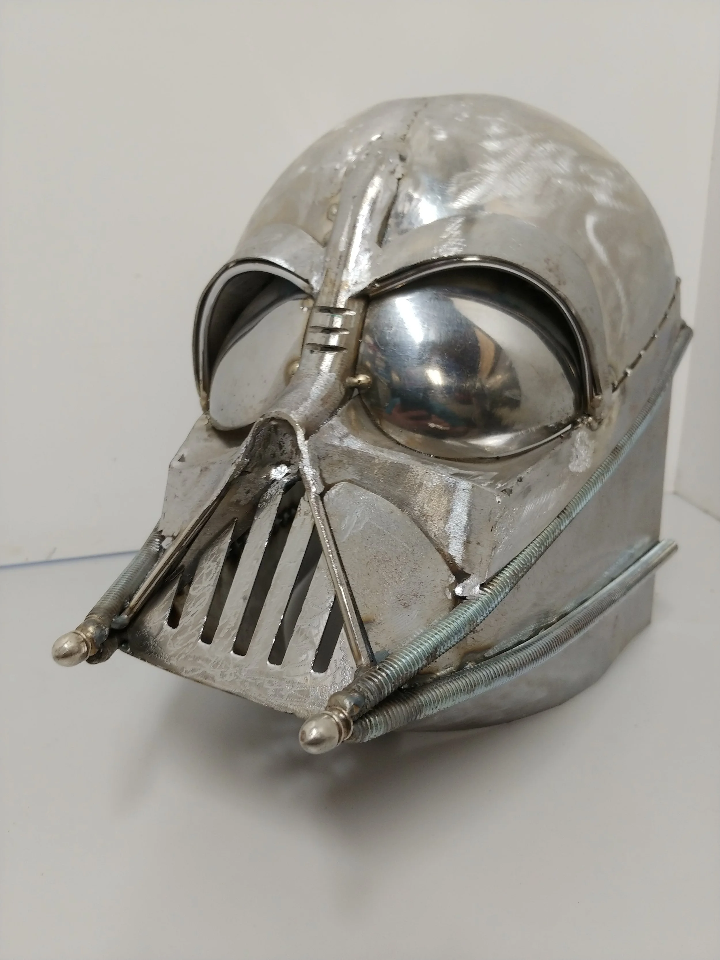 A comic-style illustration depicting a post-apocalyptic city scene. The city is in ruins with collapsed buildings, wrecked cars, and debris. In the foreground, a person walks through the rubble, while a large robot stands amidst the destruction. In the background, a massive mushroom cloud from an explosion rises into the sky, which is colored in shades of orange and yellow, emphasizing the catastrophic event.