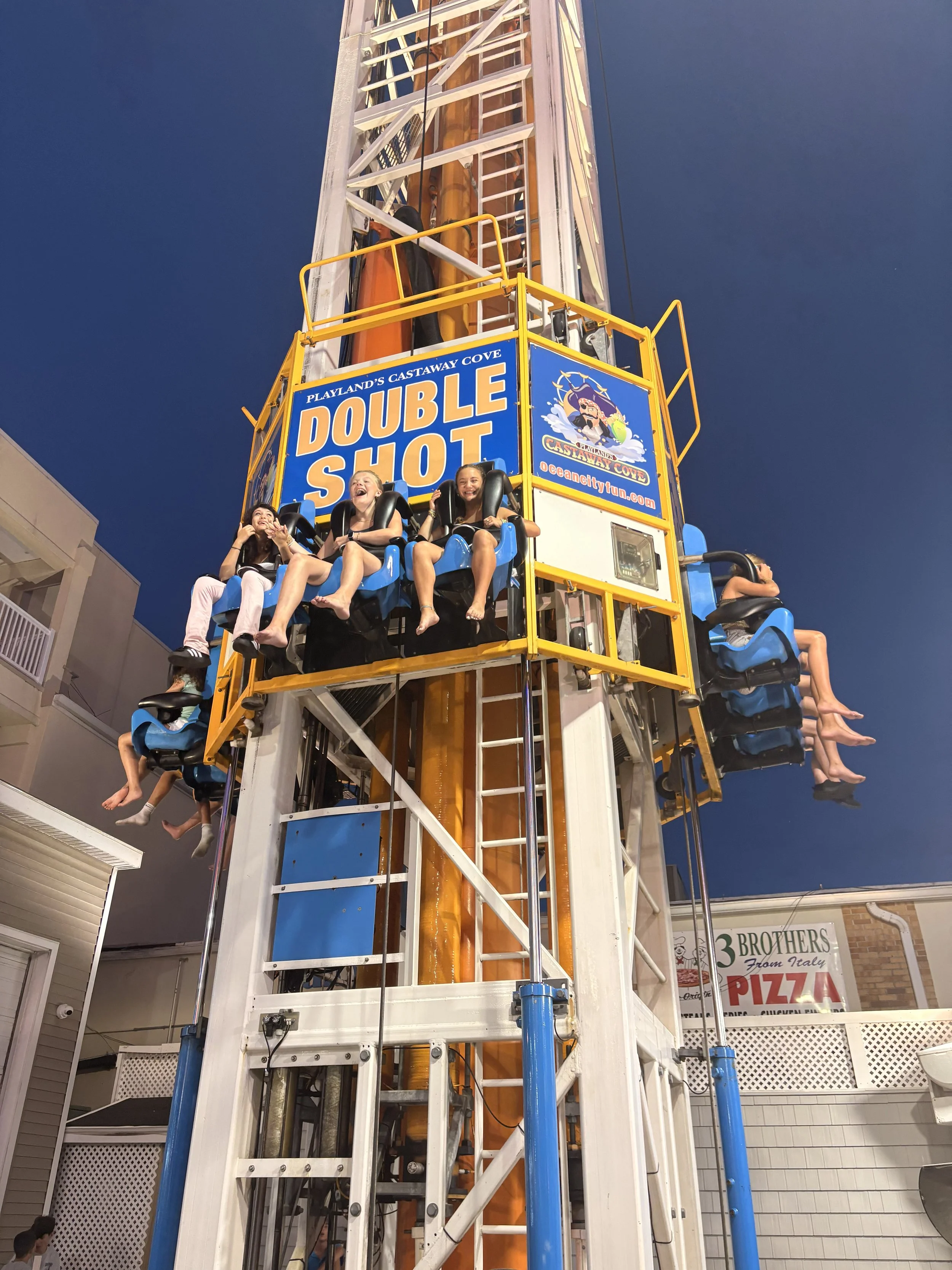 A large amusement park ride called 'Double Shot' at Playland's Castaway Cove with riders seated at the top, enjoying the ride.