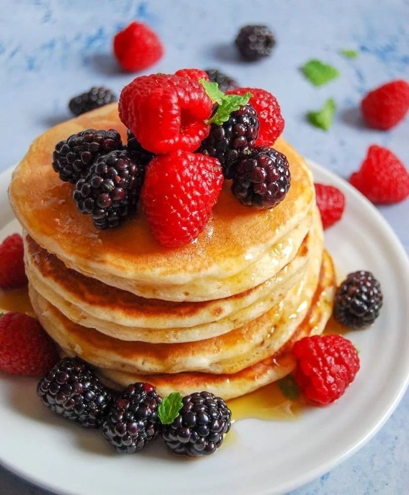 Stack of pancakes topped with fresh berries from the Signature Brunch menu