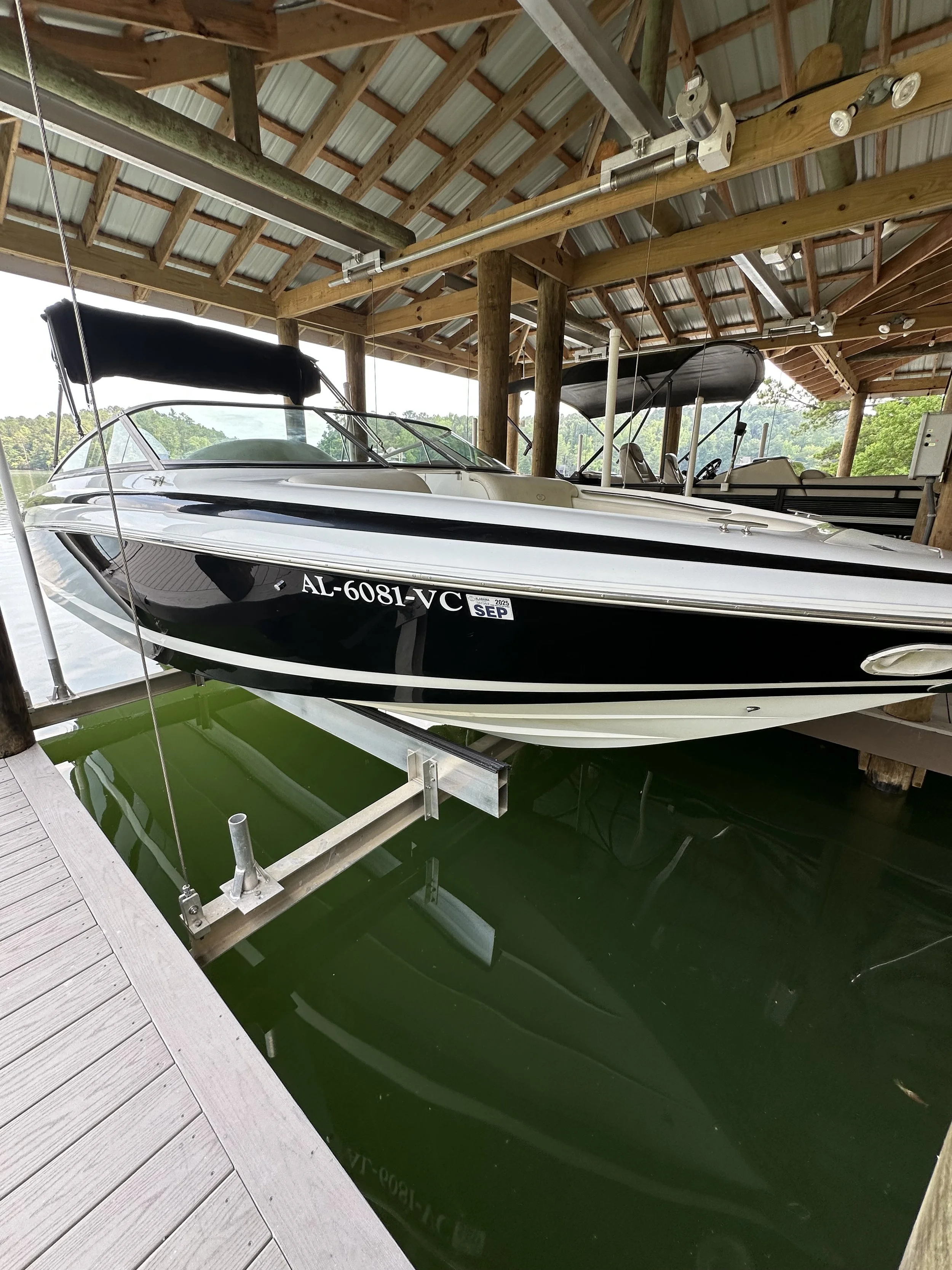 Three bottles of yacht surface maintenance products labeled: Level-R, Finish-R, and Hyper Hold Pro, placed outdoors on a wooden surface.