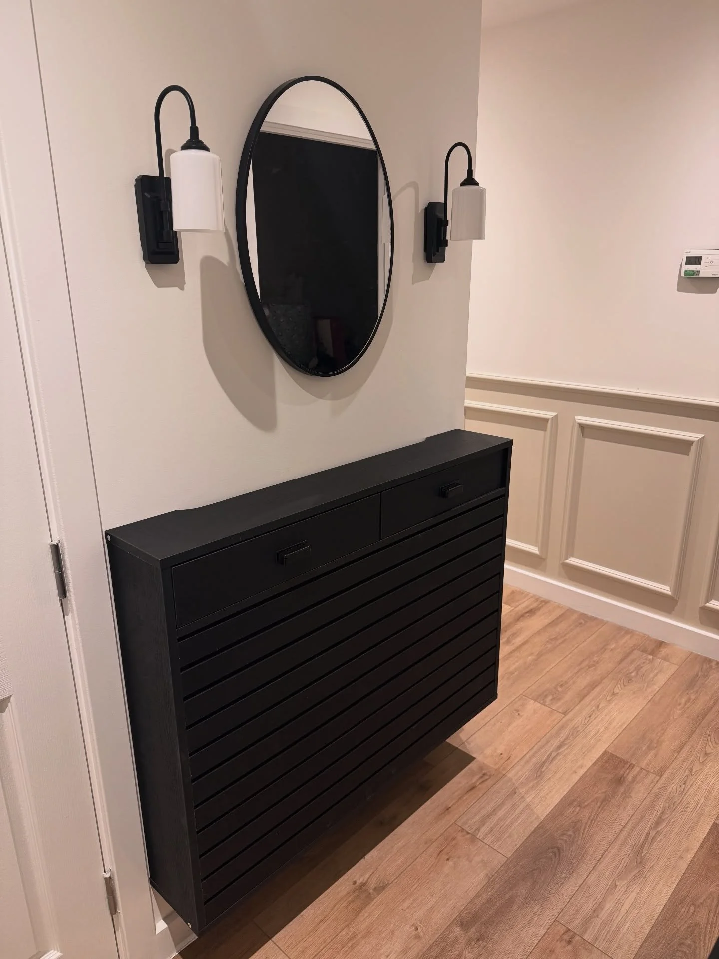 Welcome to our latest transformation in Burgess Hill! ✨ We&rsquo;ve given this flat a fresh new vibe with 55 square meters of timeless oak LVT flooring, chic half-height paneling painted in a perfect nude, a beautifully lit hallway mirror, and a cozy