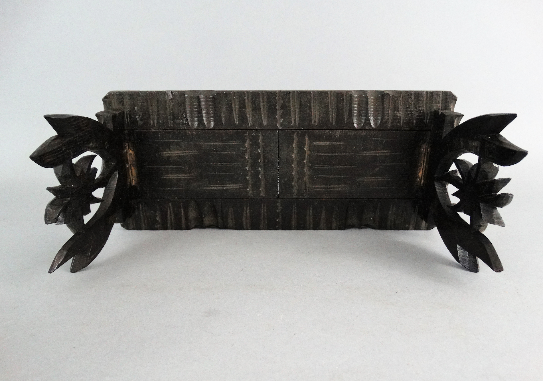 An early 20th-century carved telescoping Black Forest book slide. It has carved palm trees on both ends. Located in Austin, Texas.