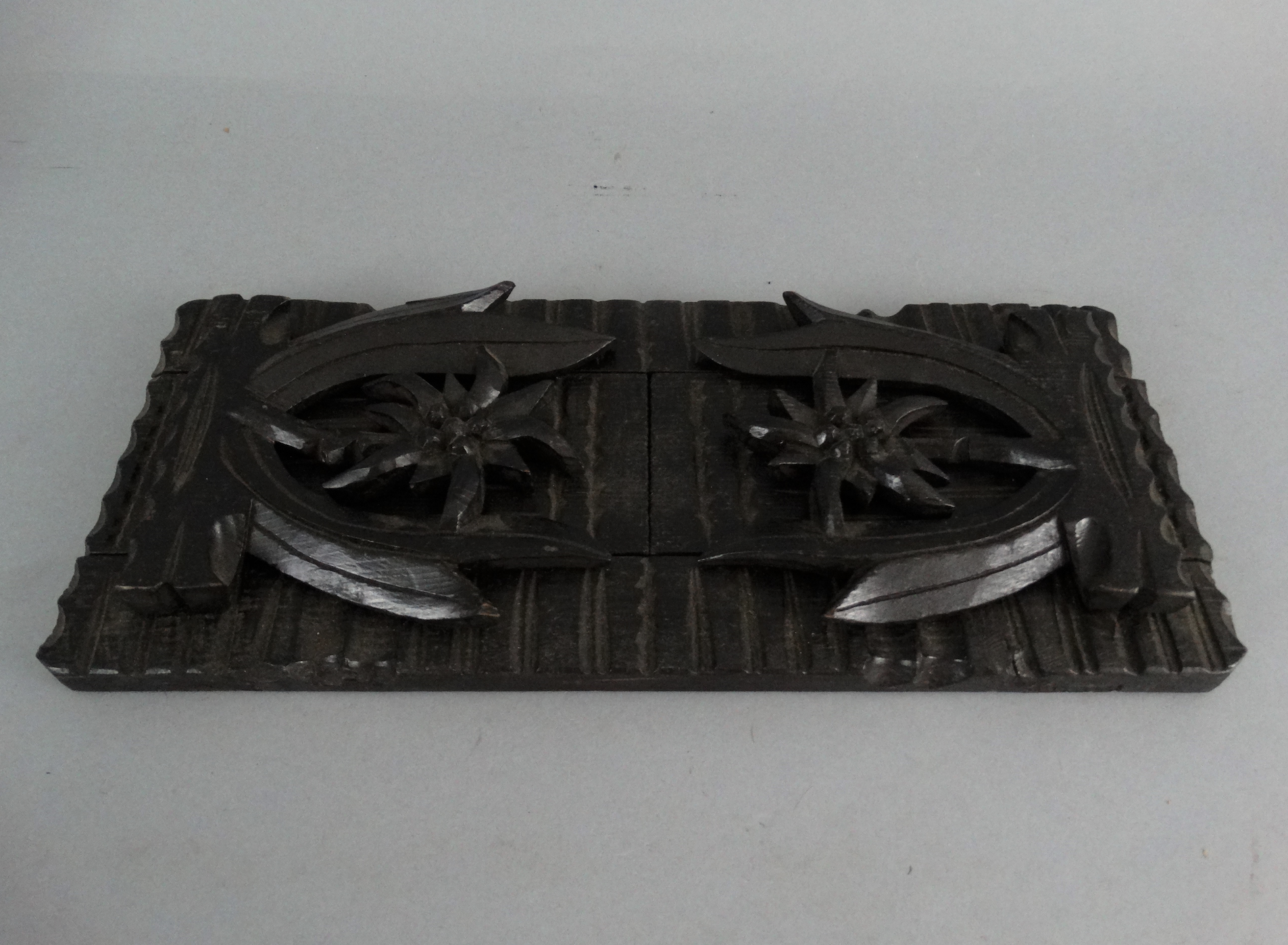 An early 20th-century carved telescoping Black Forest book slide. It has carved palm trees on both ends. Located in Austin, Texas.