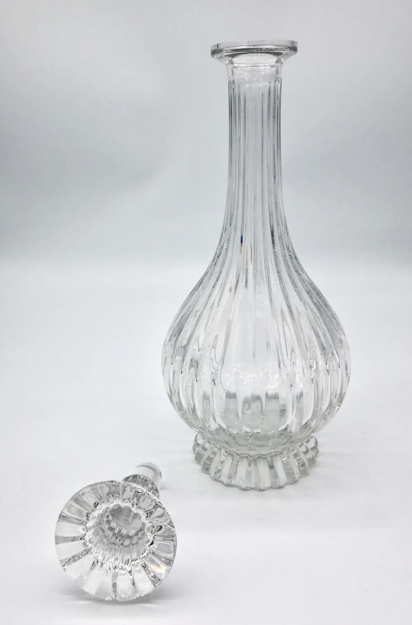 Tall, stunning glass decanter perfect for holding your favorite liquor or staged on a bar cart. Located in Austin, Texas.