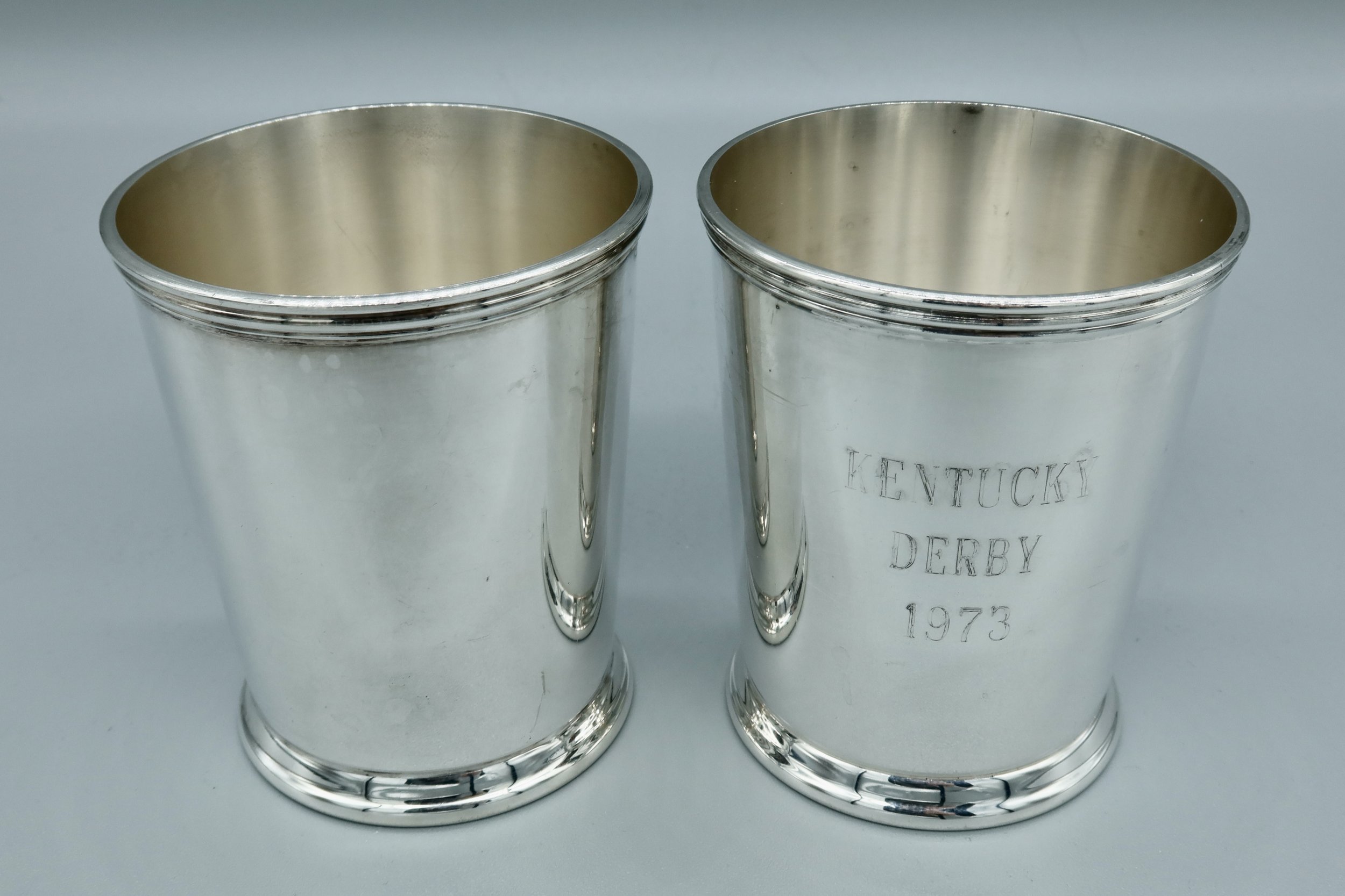 Pair of silverplate mint julep cups engraved “KENTUCKY DERBY 1973” on the exterior, with maker’s mark on the underside. Located in Austin, Texas.