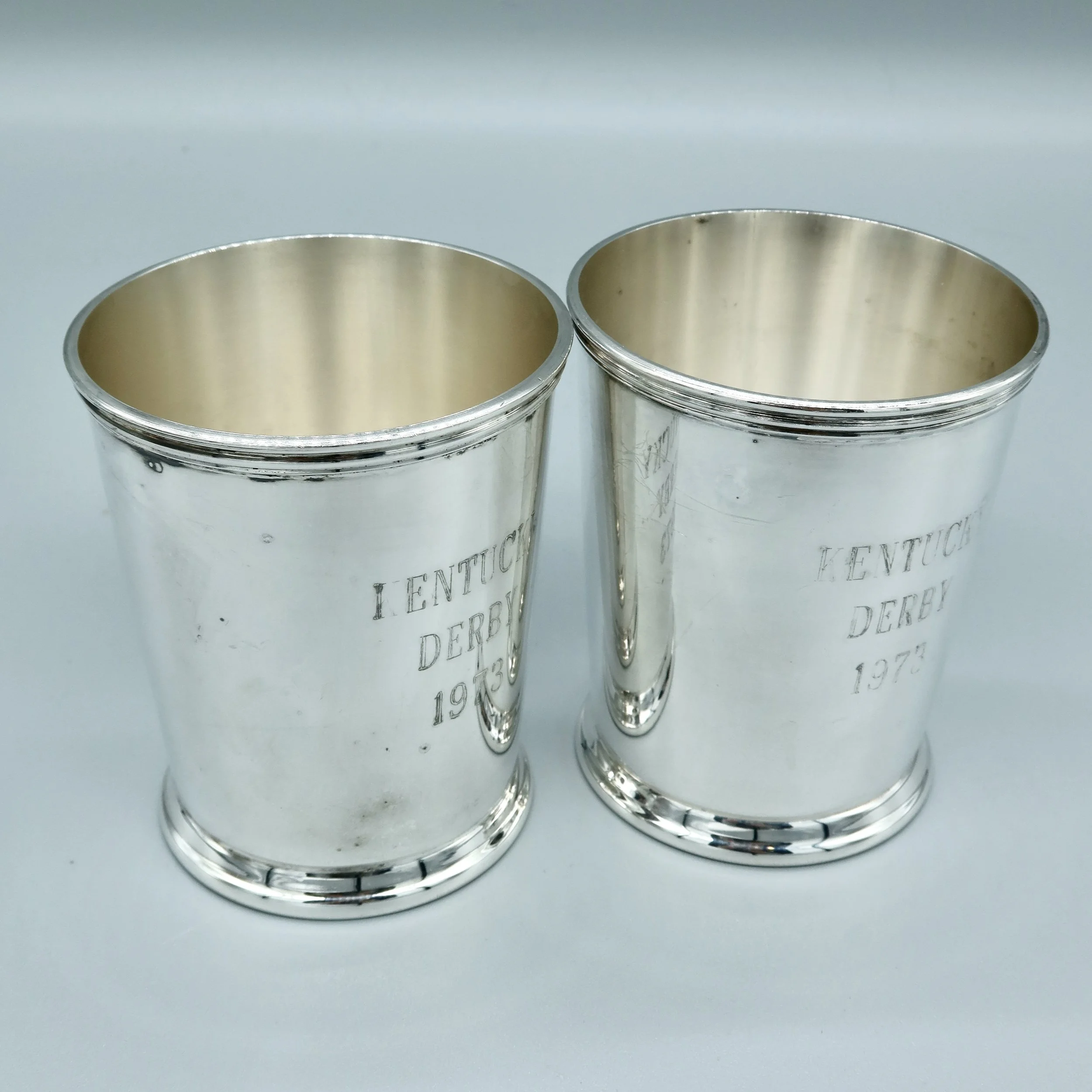 Pair of silverplate mint julep cups engraved “KENTUCKY DERBY 1973” on the exterior, with maker’s mark on the underside. Located in Austin, Texas.