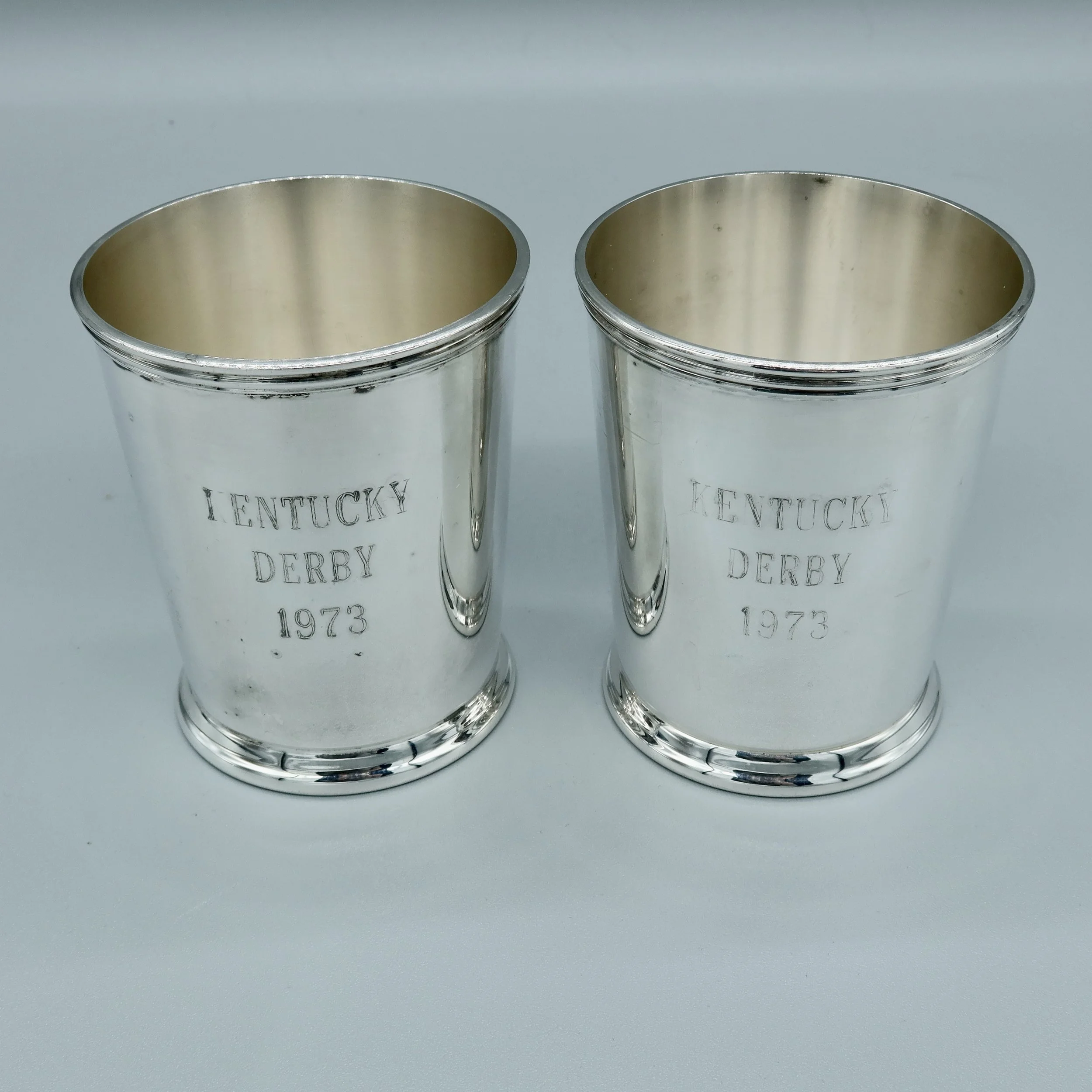 Pair of silverplate mint julep cups engraved “KENTUCKY DERBY 1973” on the exterior, with maker’s mark on the underside. Located in Austin, Texas.
