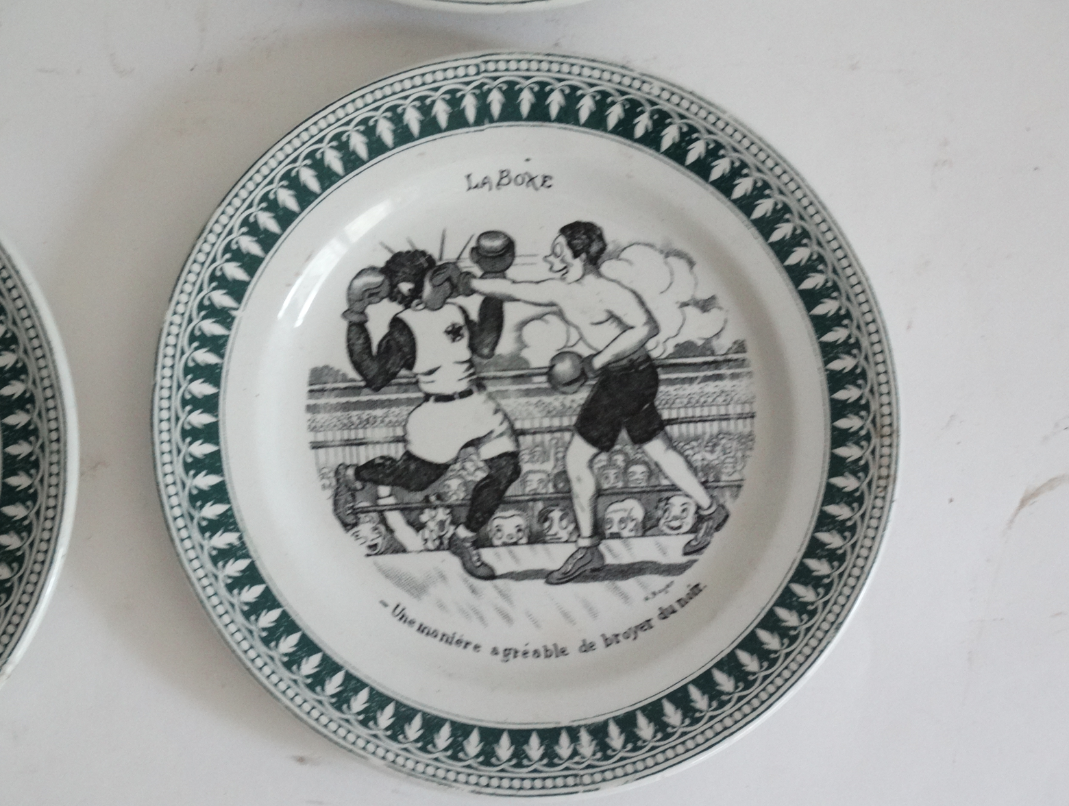 Four French faience sporting plates from St Amand factory, circa 1920. Includes Le Tennis, La Course Pied, La Boxe, L’Aviation, and l'Automobilisme. Located in Austin, Texas.