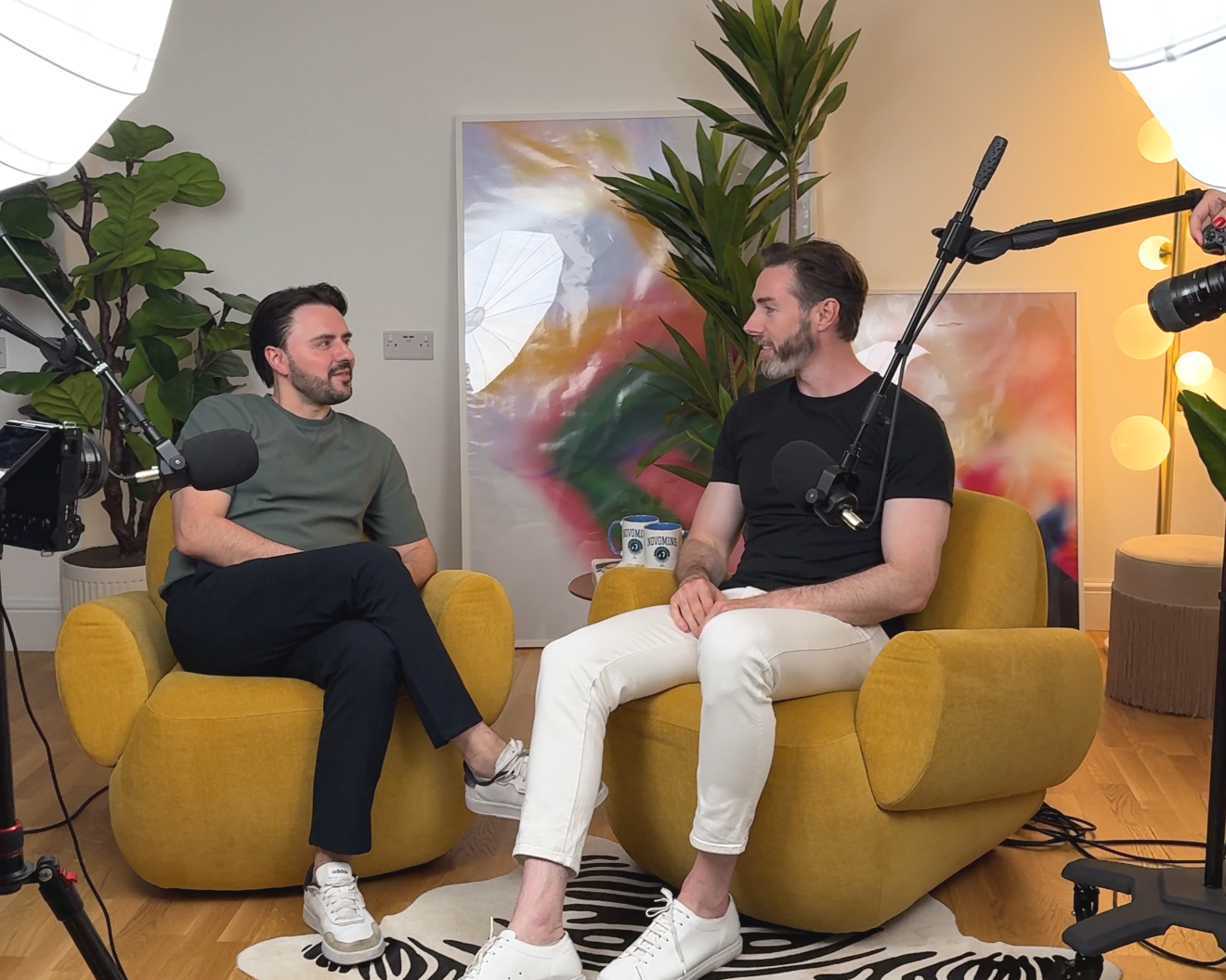 Two hosts recording a video podcast on yellow armchairs with boom microphones at LND Studio, West London