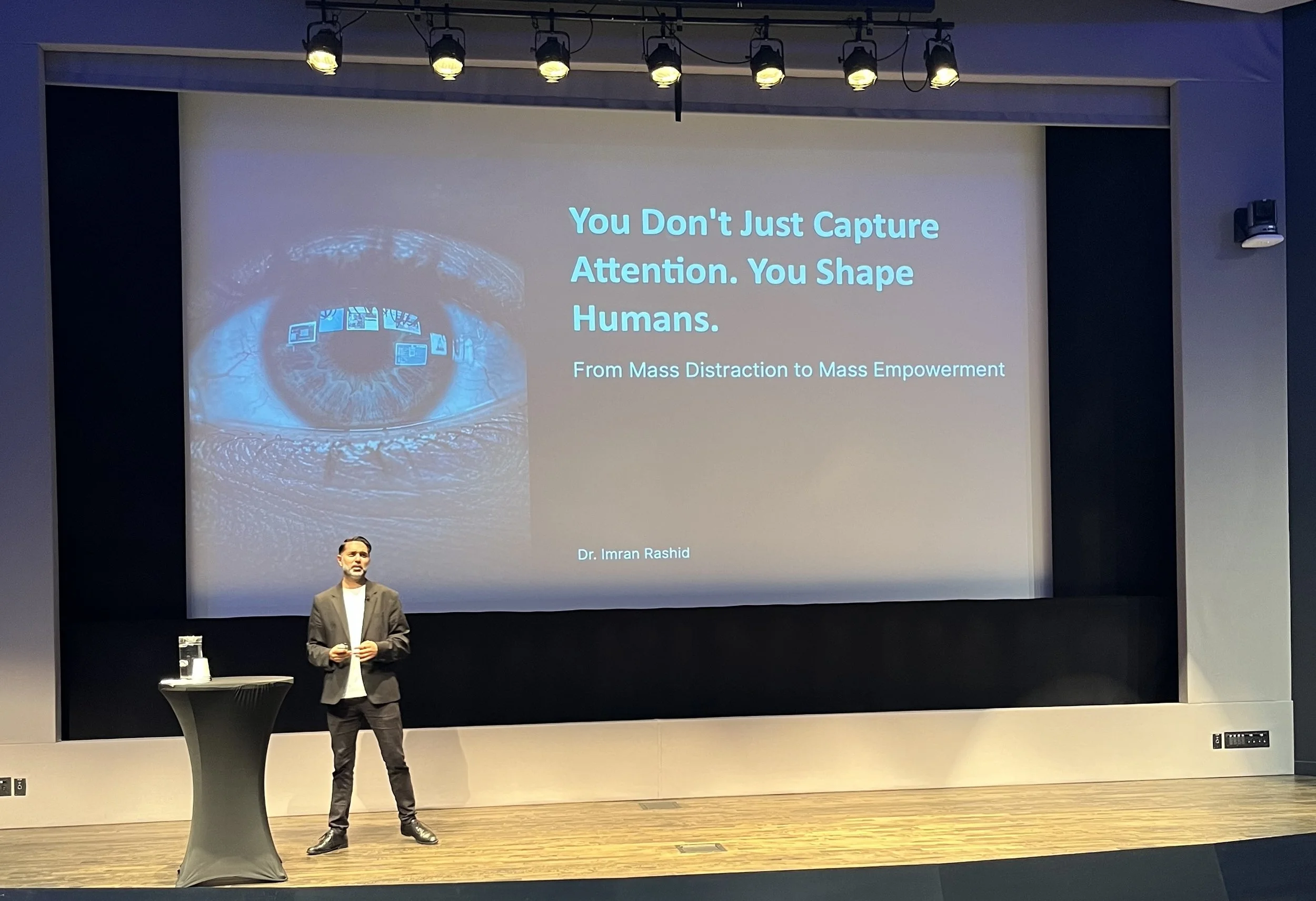 Speaker presenting on stage at Branded Content Days with a slide reading “You Don’t Just Capture Attention. You Shape Humans.”