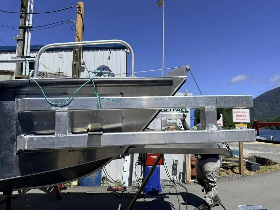 Welder installing custom push bumper on new vessel