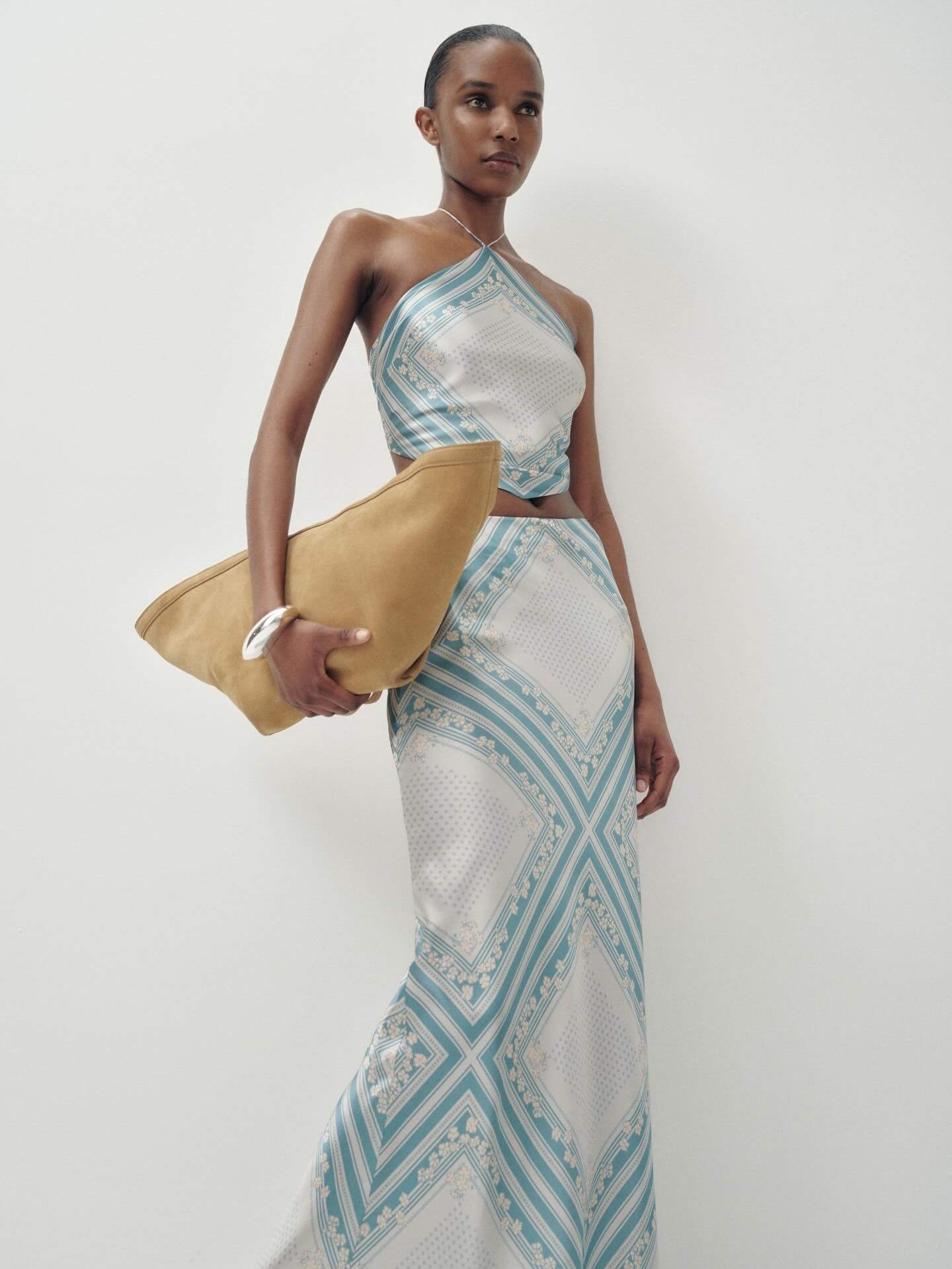 Silk halter scarf top and matching midi skirt set in blue and ivory print, styled with a neutral suede clutch for an elevated summer outfit