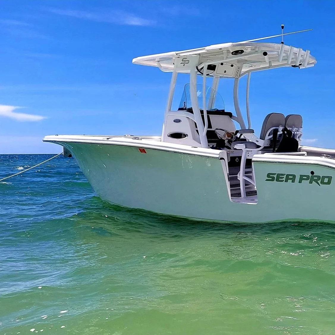 A white Sea Pro boat floating on the water under a blue sky.
