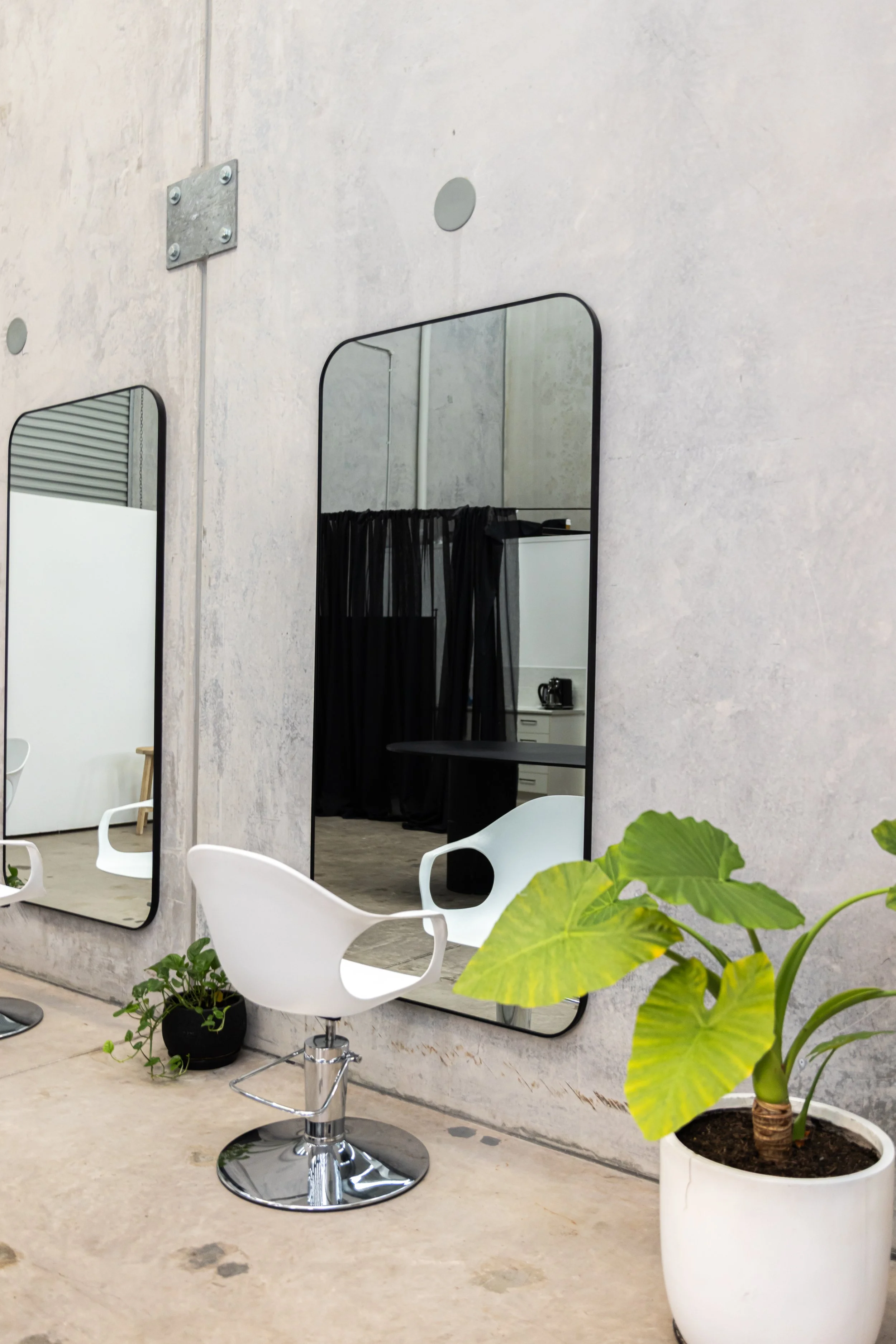 Modern salon chair with large mirror in a bright, professional beauty space designed for independent stylists.