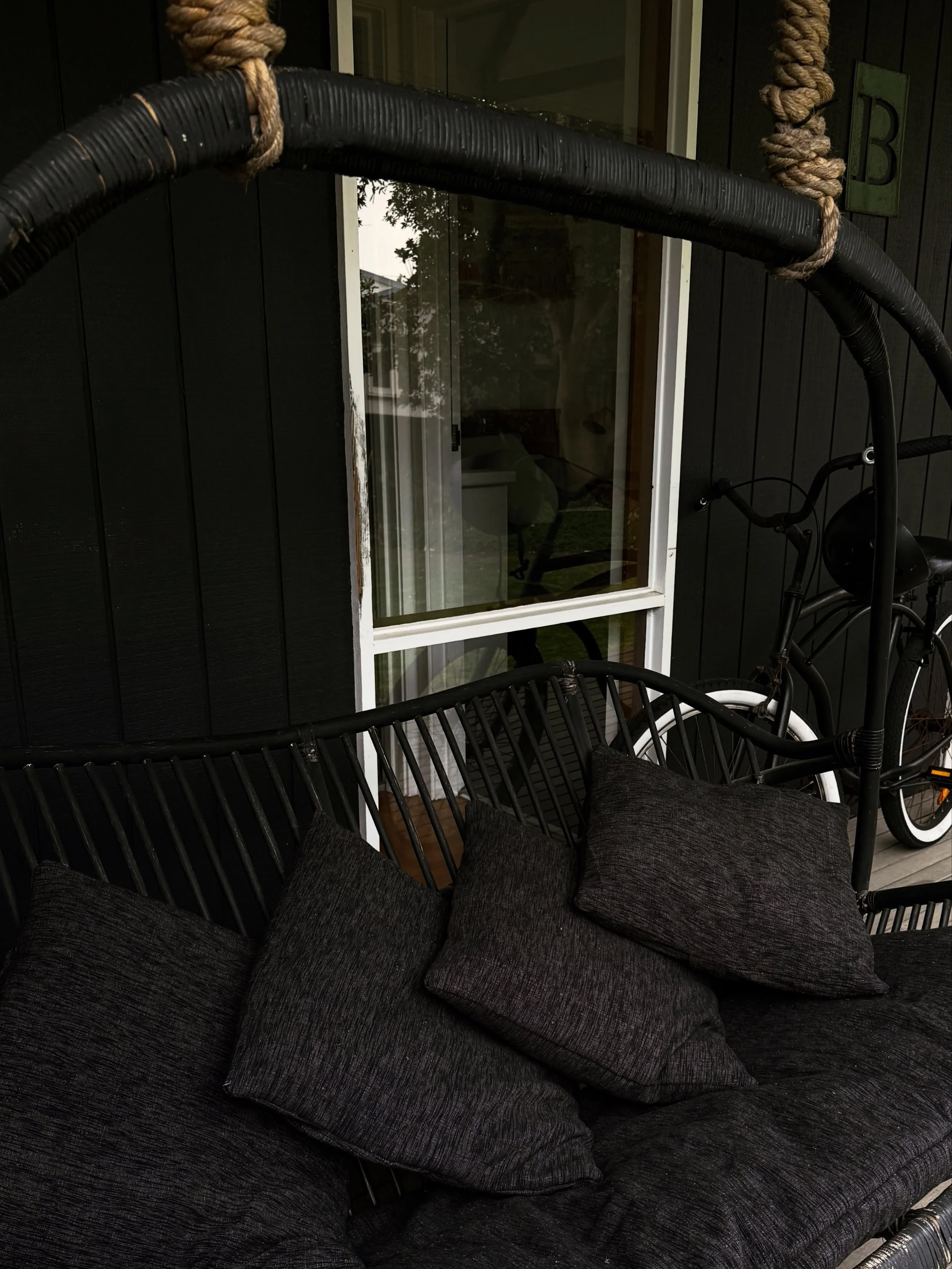 The swingy love seat now has freshly covered linen cushions, in trusty black.