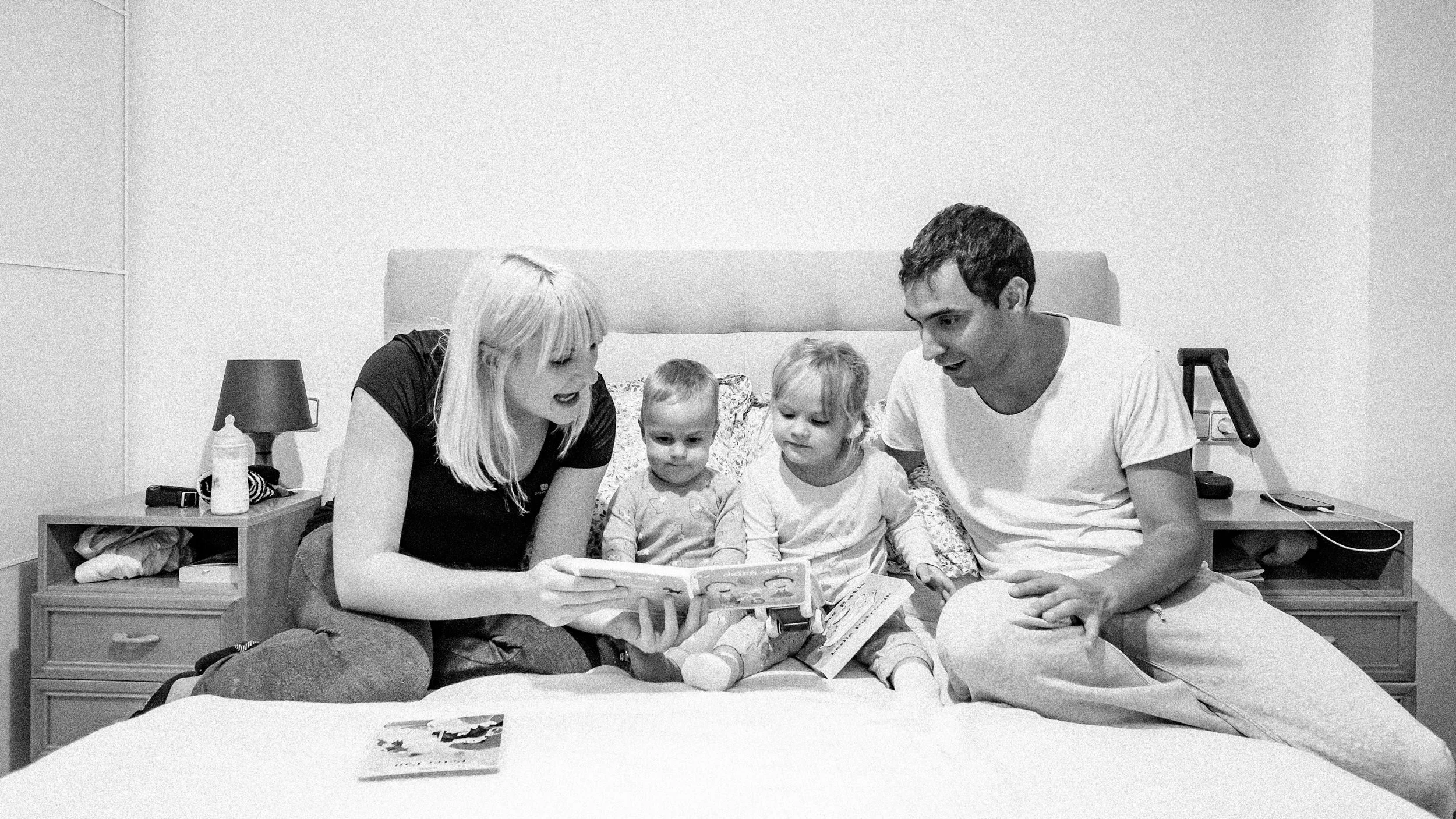 fotografia de familia leyendo en la cama