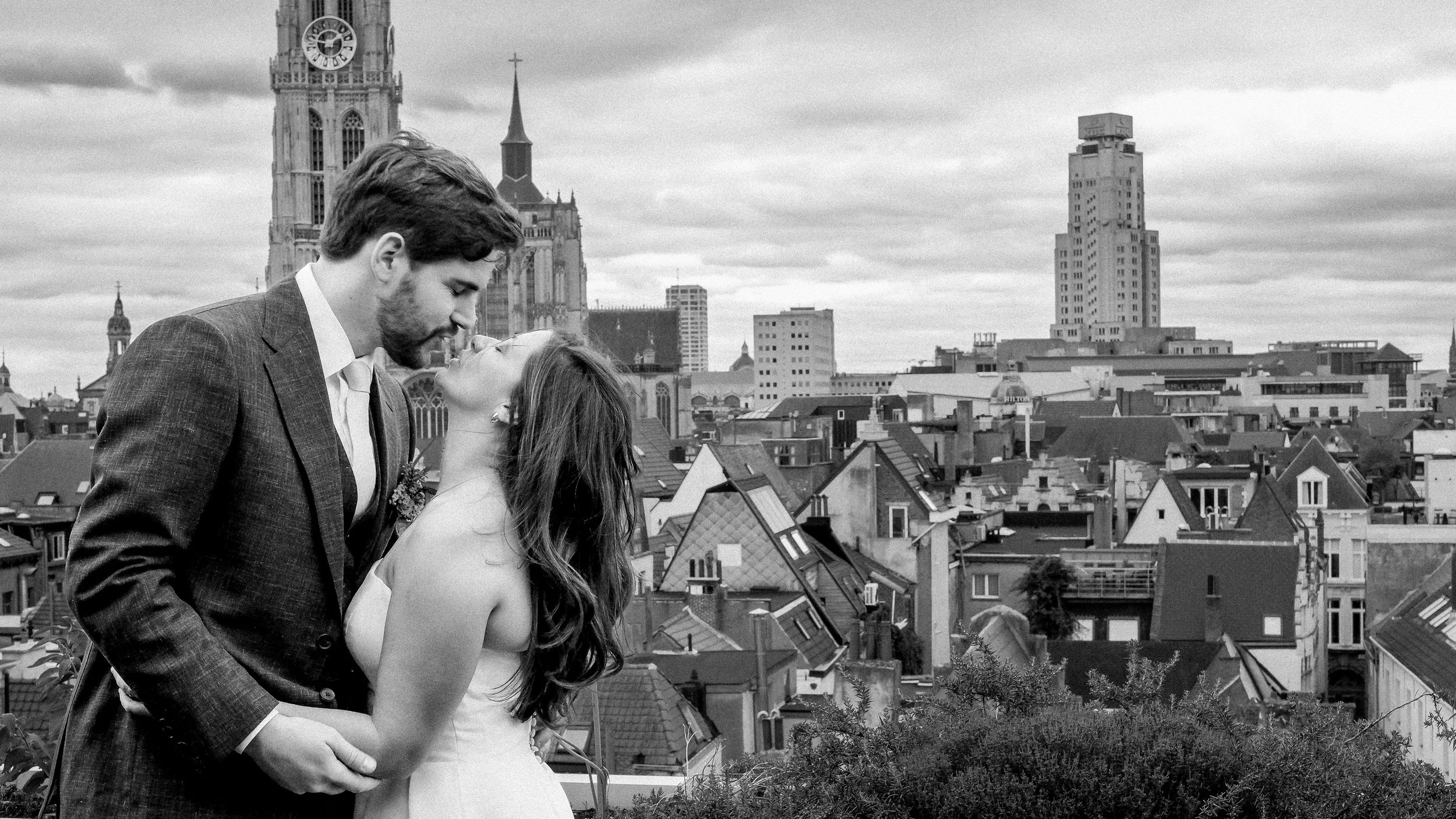 Phaedra and Jef kiss on a rooftop overlooking Antwerp on their wedding day