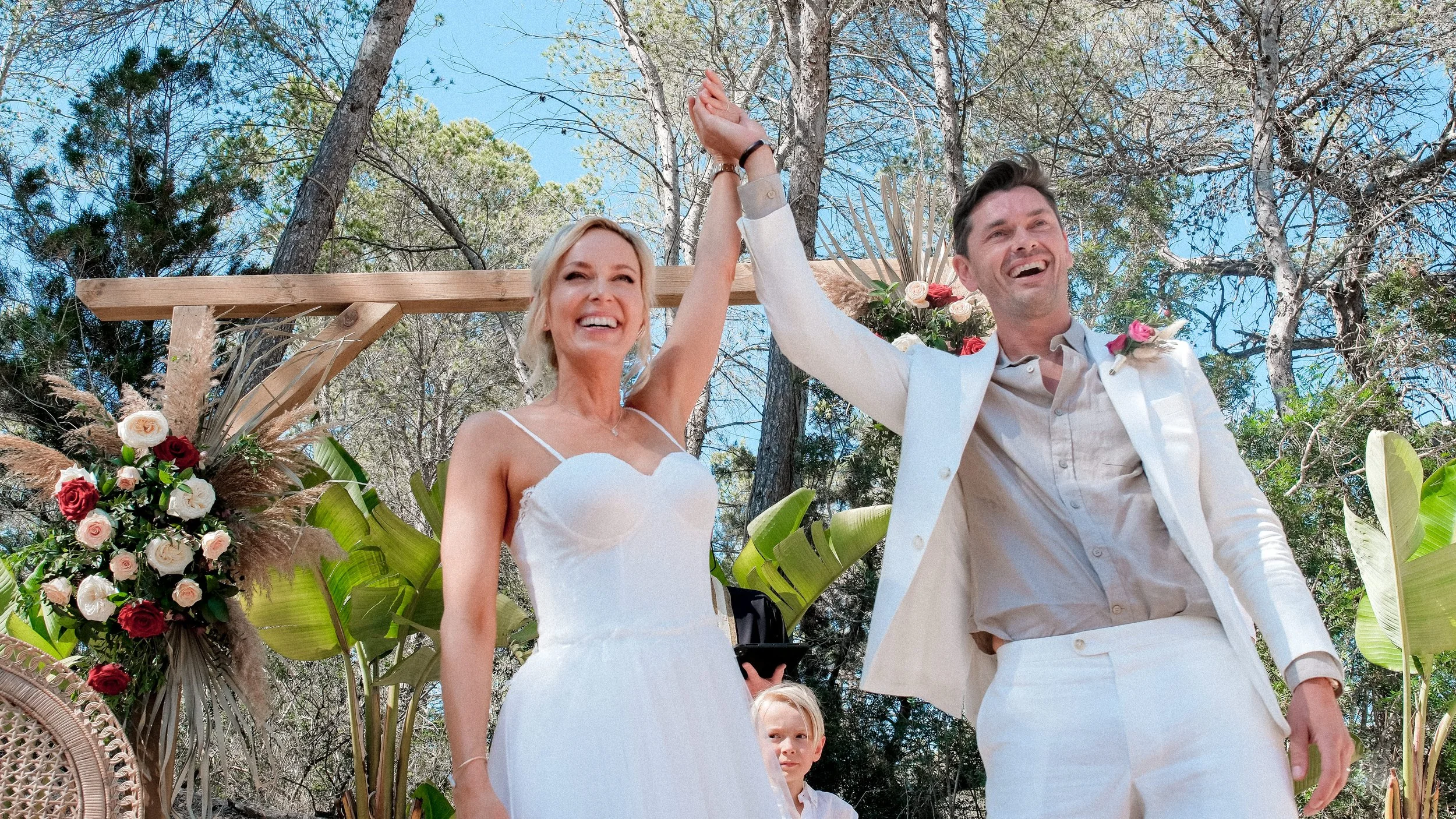 Joyful ceremony moment during a Belgian couple’s destination wedding in Ibiza — celebrating under Mediterranean sunlight with natural floral decor.