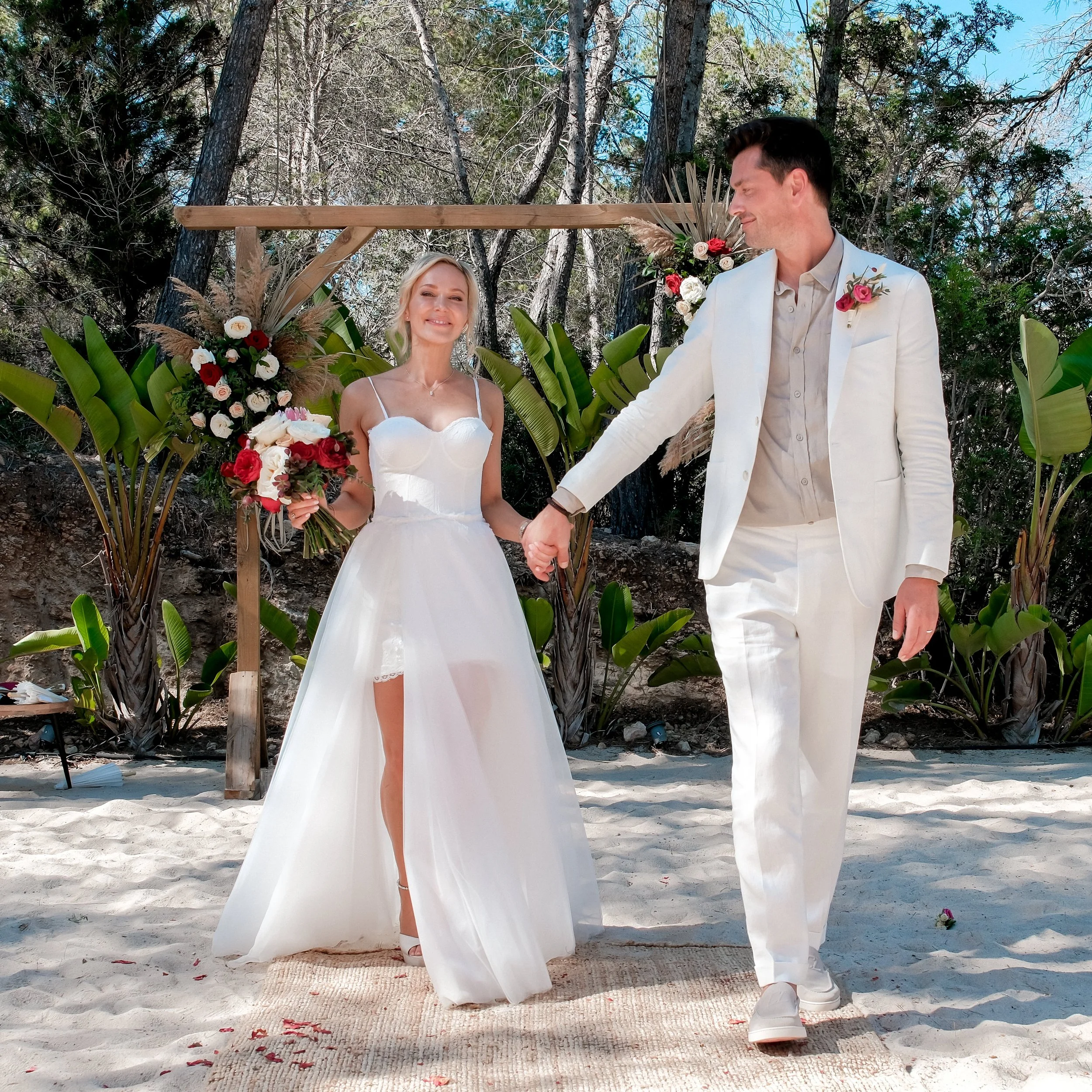 Bride and groom walking together on the sand at The Rock in Ibiza during an intimate destination beach wedding.