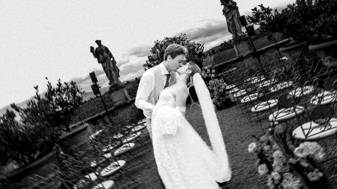 Bride and groom kissing in the ceremony space at Villa Corsini, elegant Belgian destination wedding in the Tuscan hills.