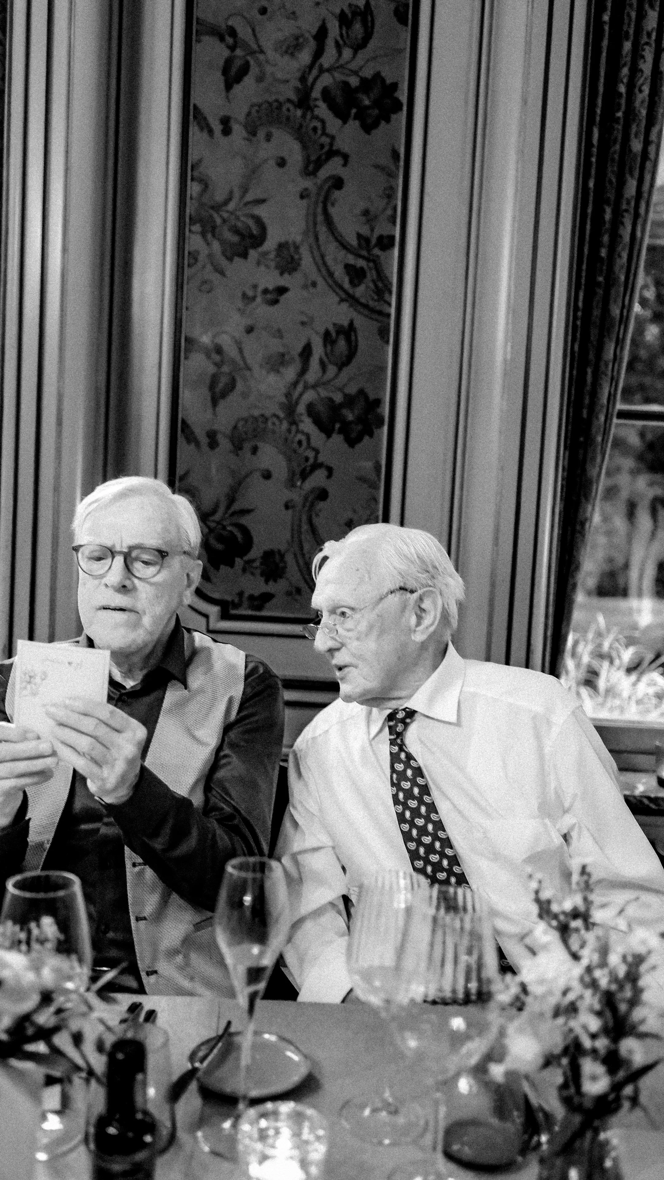 Phaedra’s grandfather and his brother looking through a photograph together during the wedding dinner in Antwerp