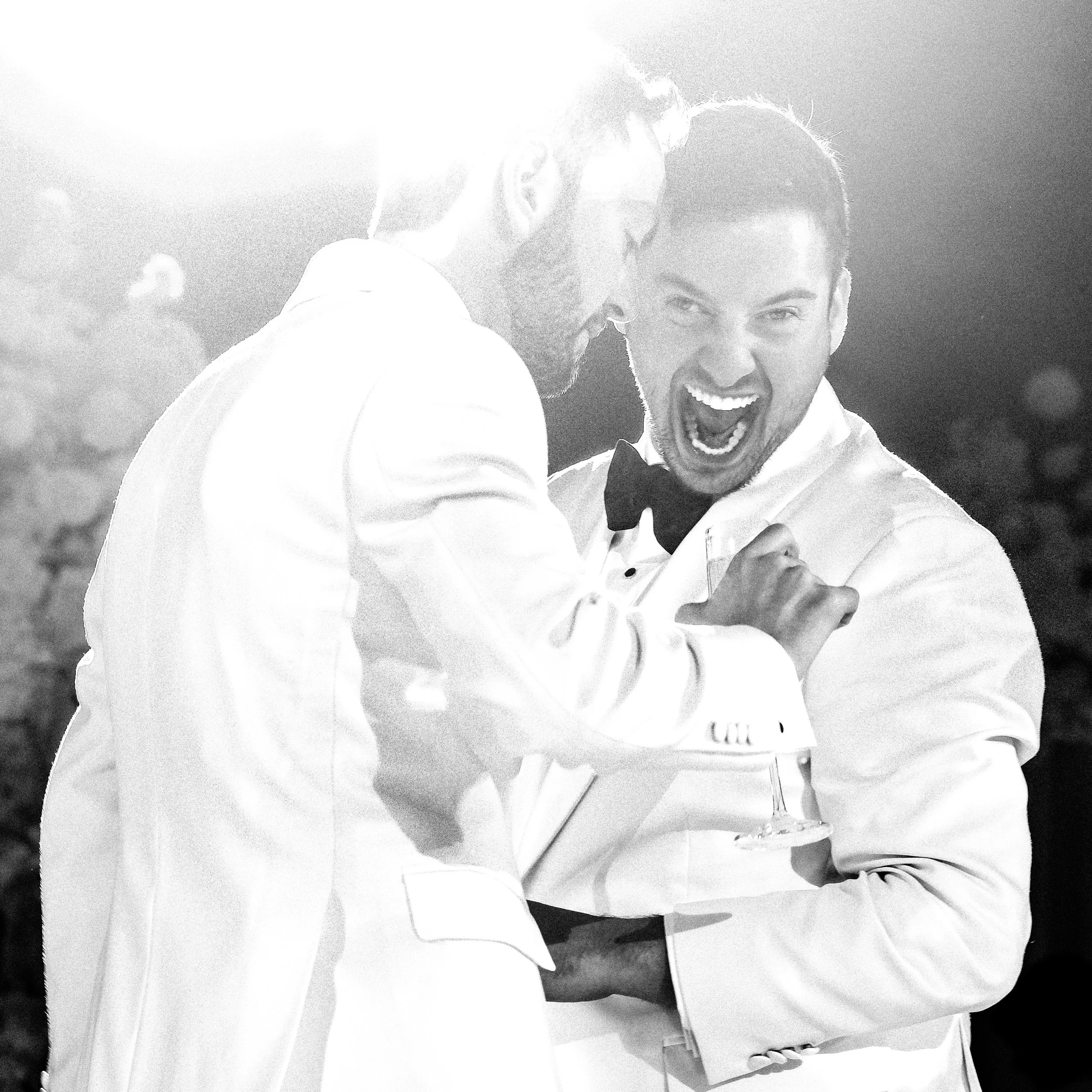 Two grooms celebrating on the dance floor at their modern Jewish wedding at the Mandarin Oriental hotel in New York City.