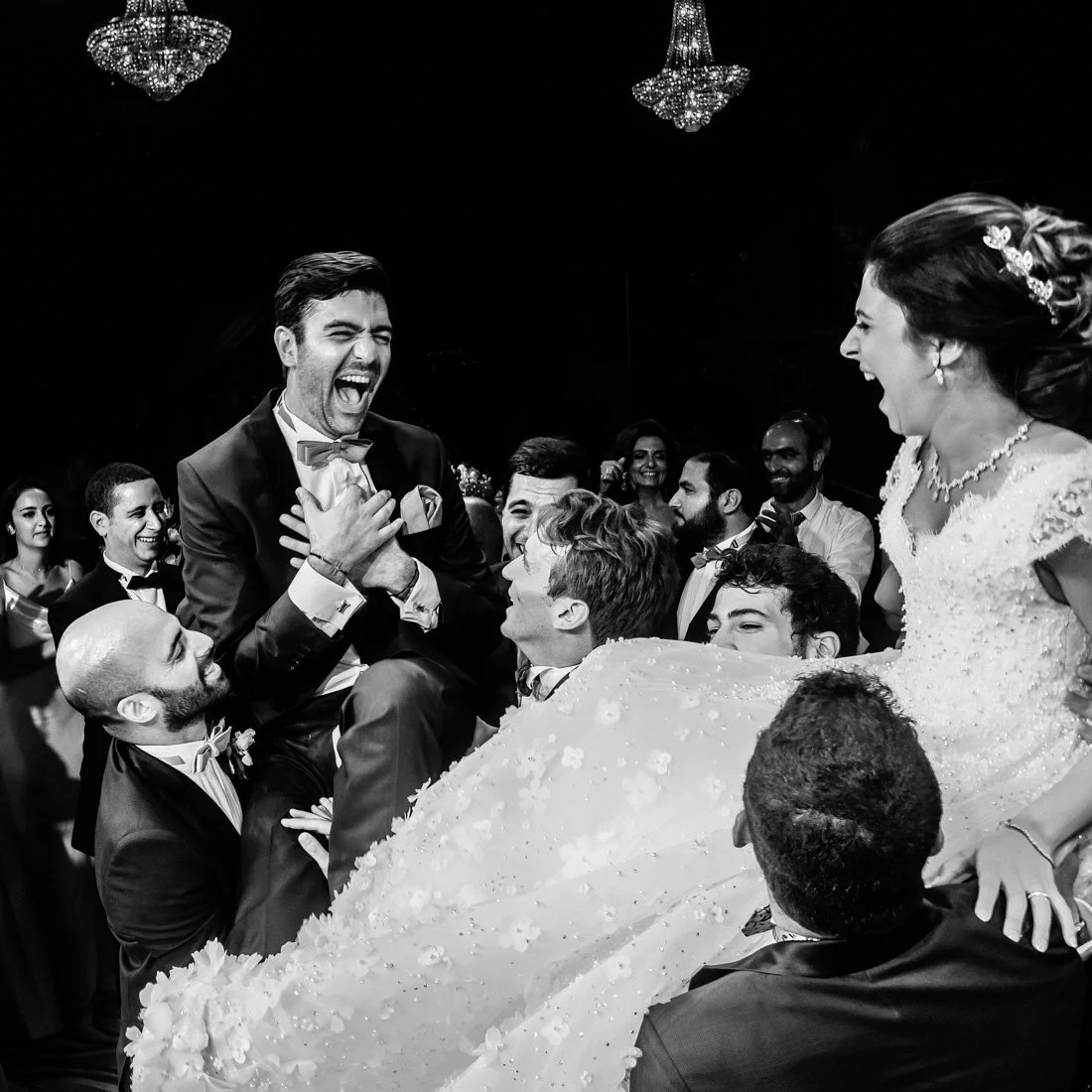 oyful moment during a Lebanese destination wedding in Europe — the groom lifted high and laughing, surrounded by friends.