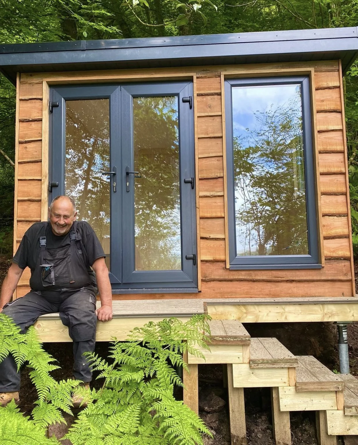 Father, Anthony Morgan sitting outside a finished woodland studio.