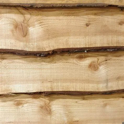 Close-up of a stack of unfinished wooden planks with visible wood grain and knots.