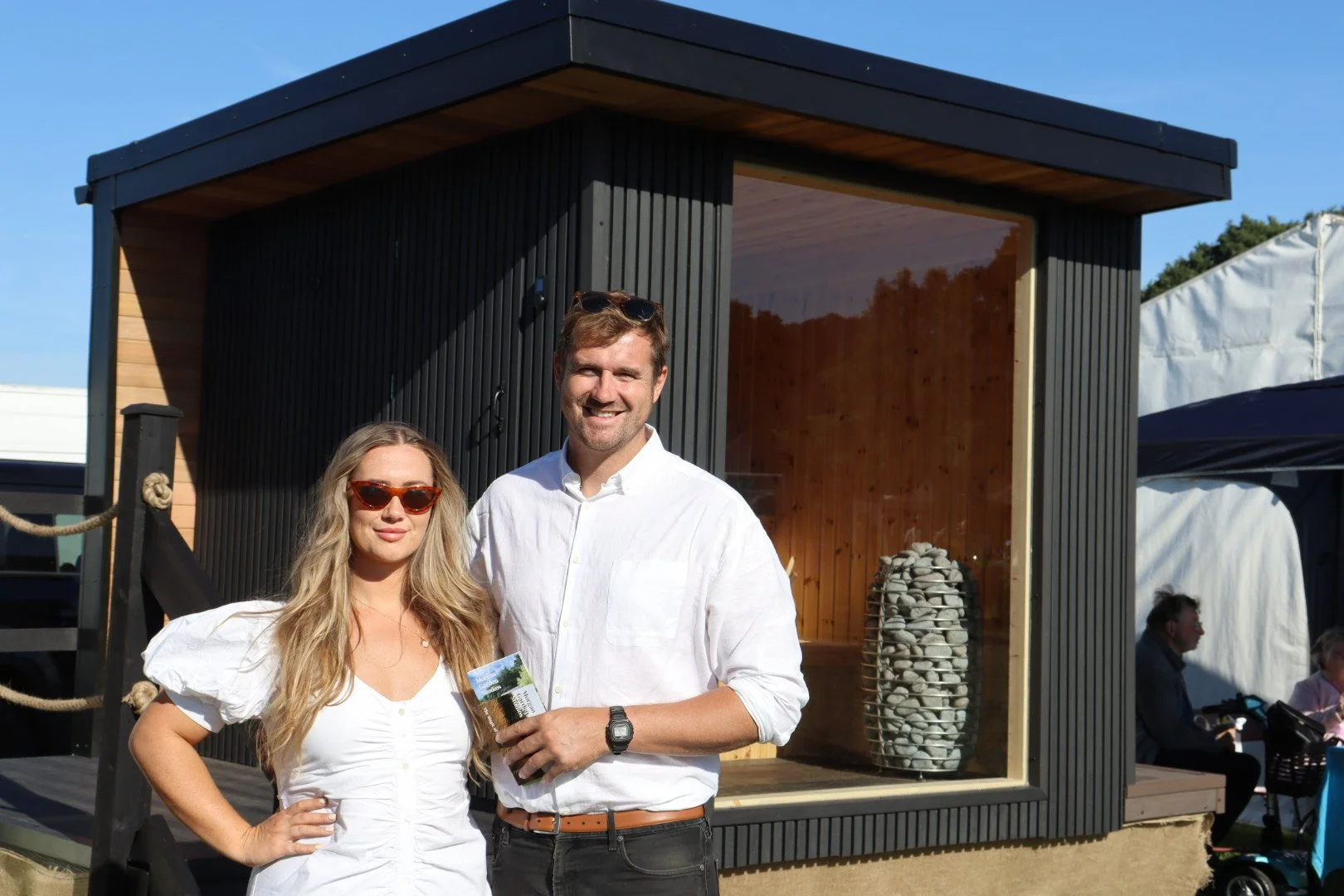 Amelia and JOhn MOrgan showcasing our hand crafted sauna in the sunshine,