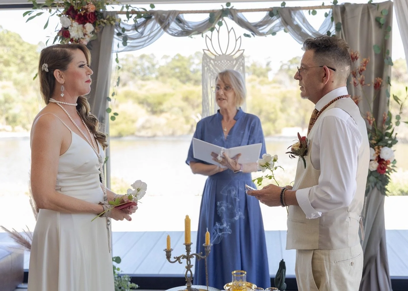 Bride and groom standing before celebrant at altar