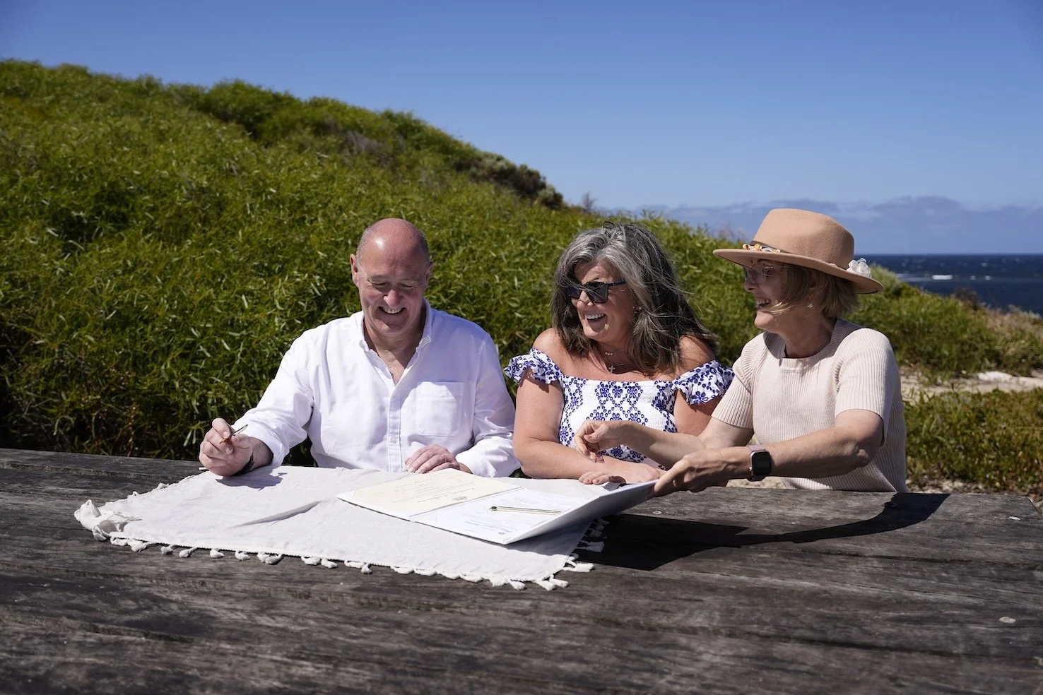Bride and groom signing marriage certificate with celebrant at beach.JPG