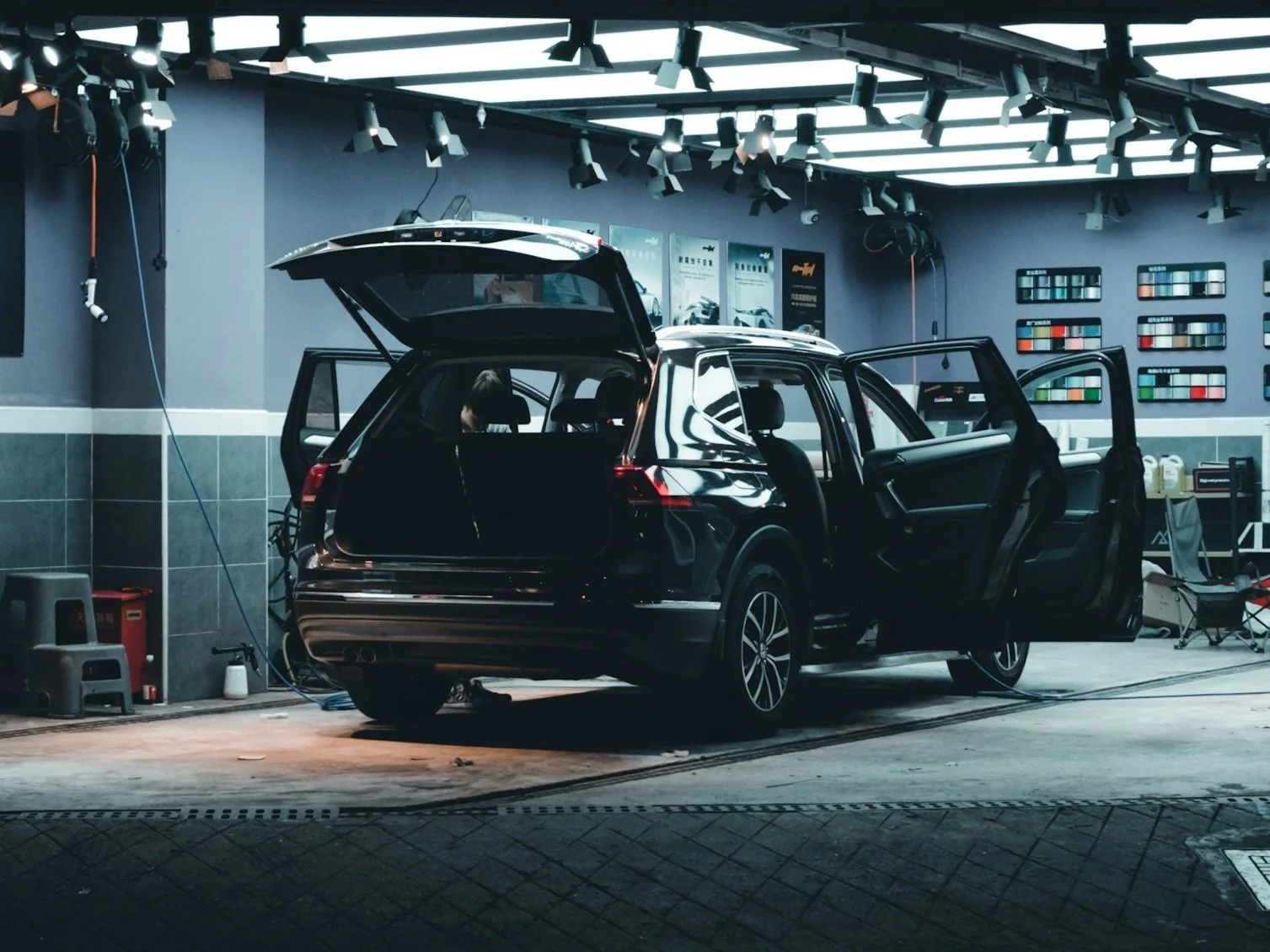 Person polishing a car bumper with a cloth and sandpaper in a workshop. Hydrographics WA, Western Australia's premier hydro dipping specialist