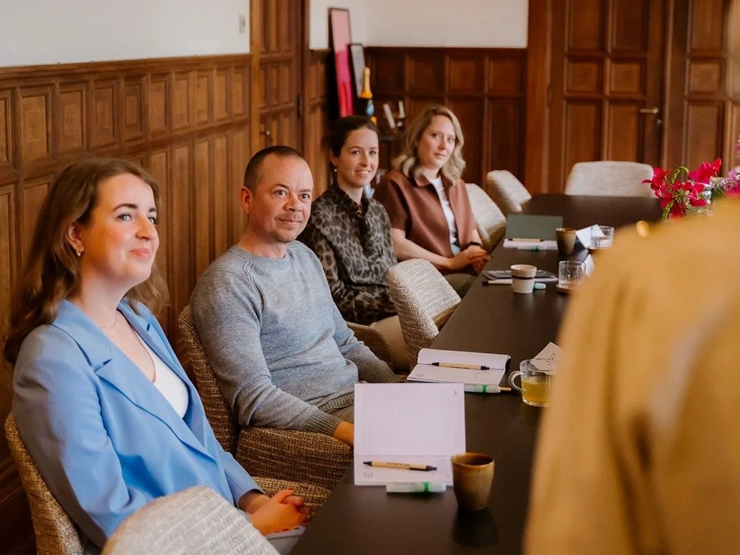 Een deel van de groep tijdens de training spreken met impact in een trainingsruimte met houten interieur. 