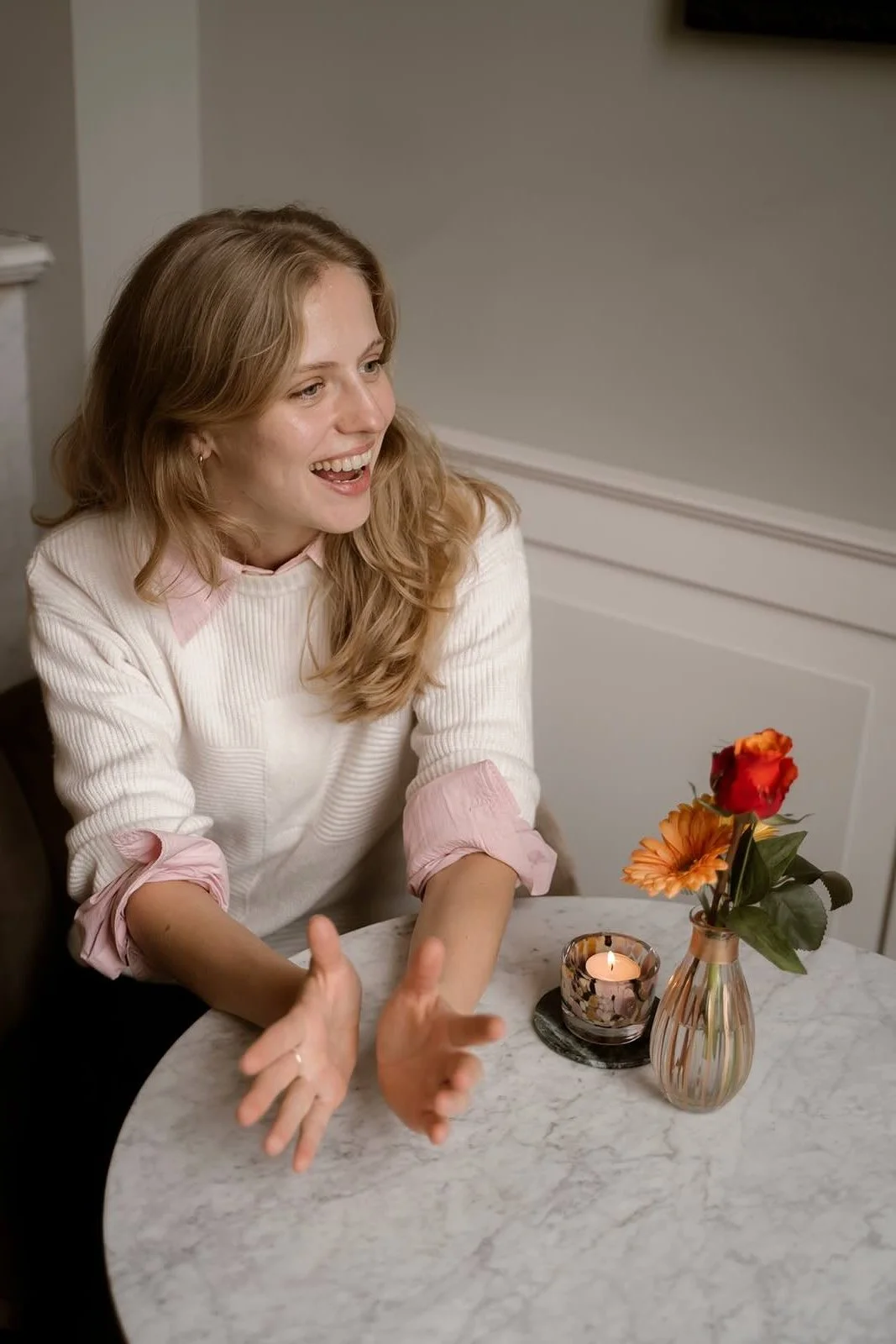 Een professional tijdens een pauze van de workshop storytelling aan een tafeltje met kaars en bloemen.