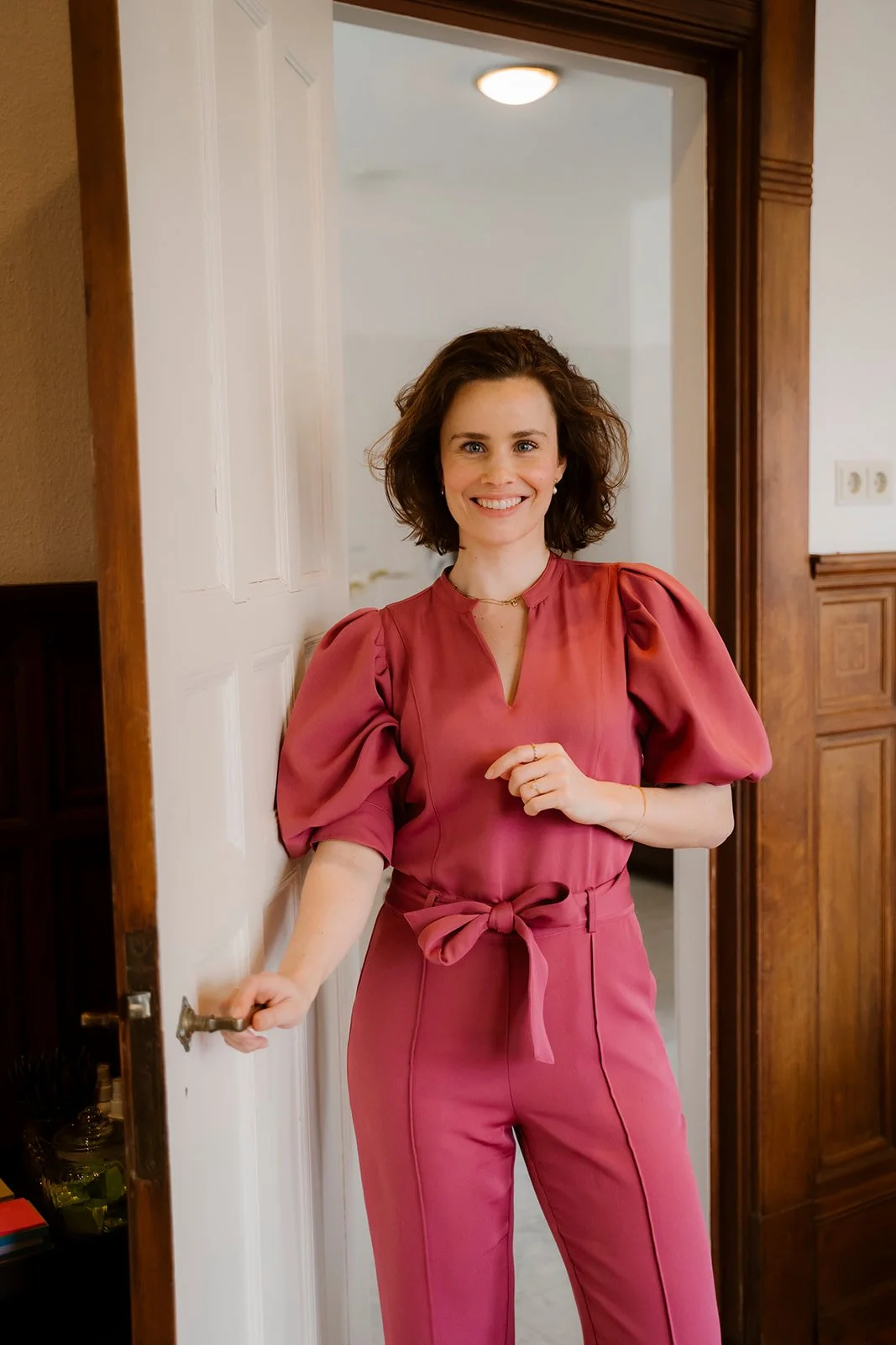 Een trainer, Lindy Bremer, in een roze jumpsuit waarin ze de training Spreken met Impact geeft in Den Haag.