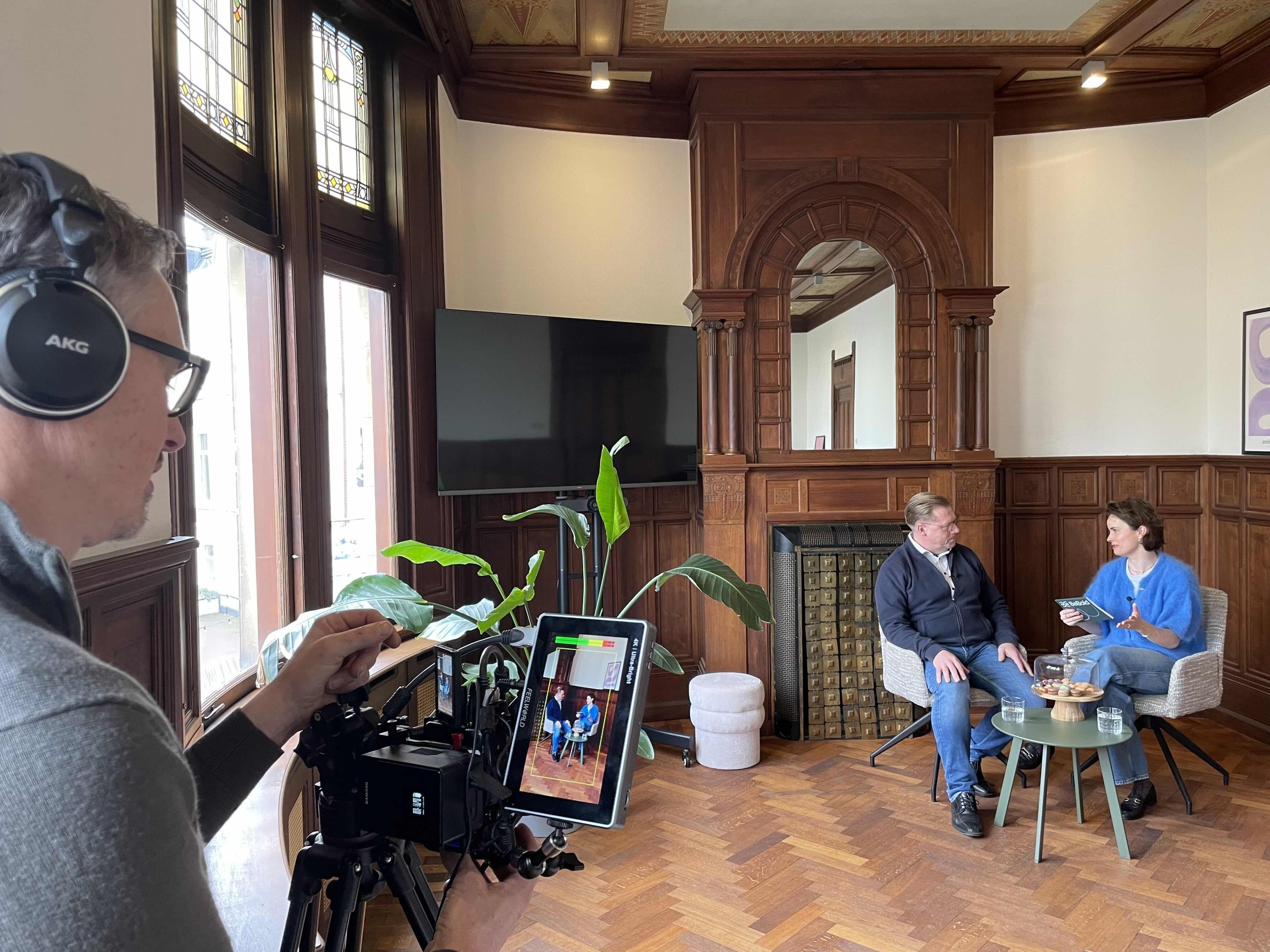 Lindy doet een camera interview met een man in een studio omgeving.