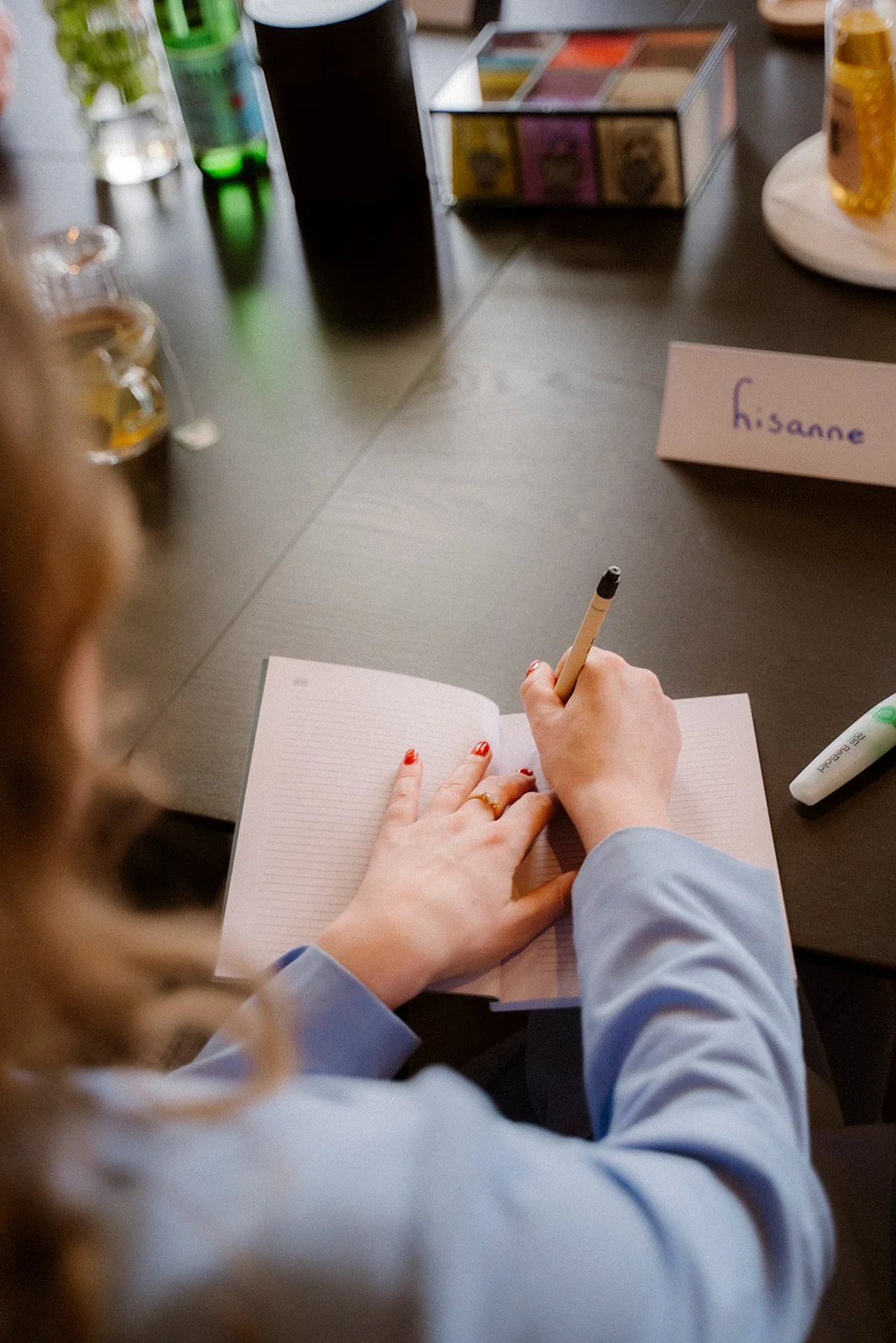 Iemand maakt notities om zo het verhaal uit het hoofd te leren. Notitieboekje ligt op een zwarte vergadertafel.