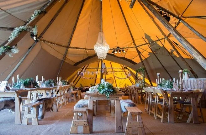 Rustic Tables and benches set up for a tipi wedding