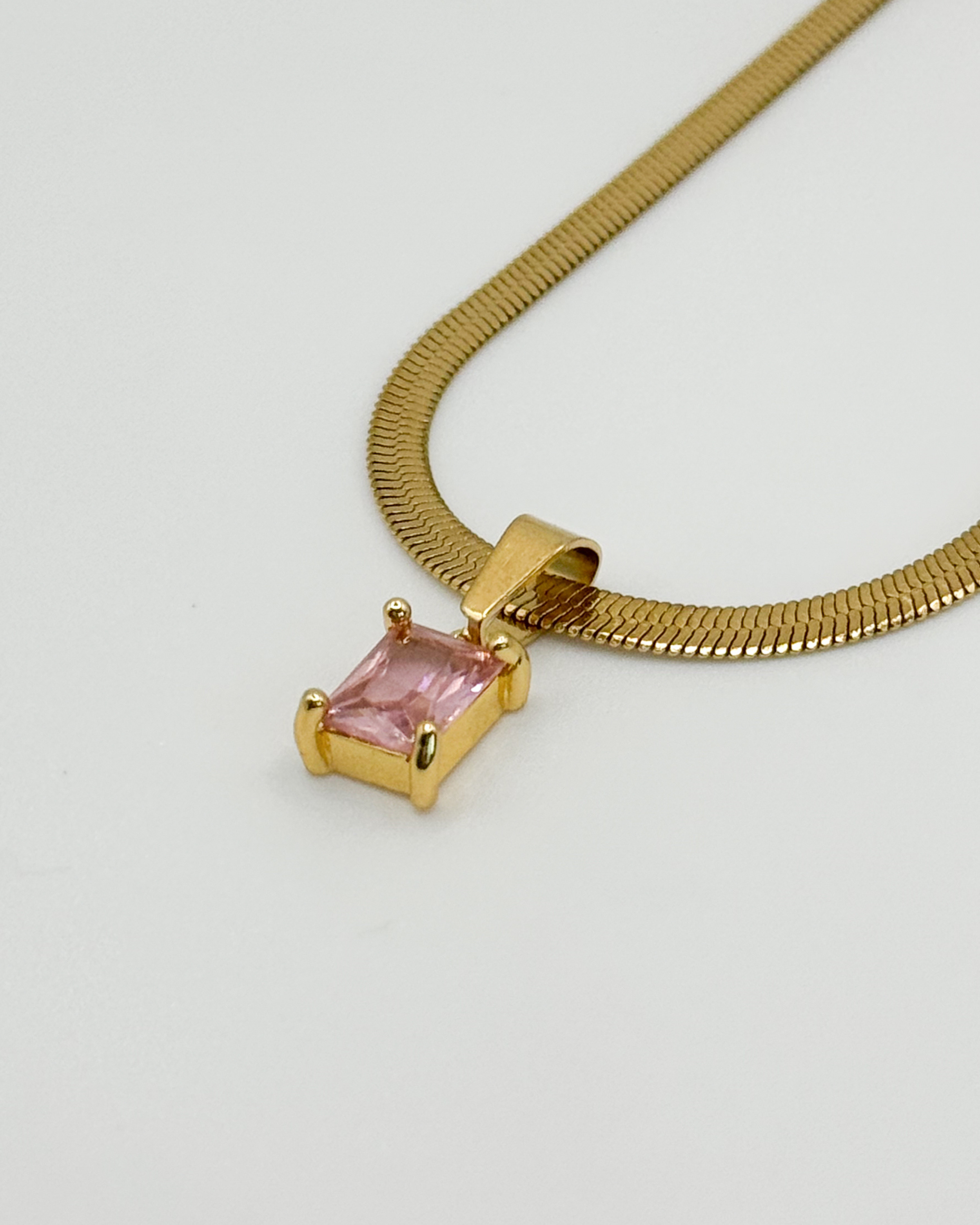 Close-up of the Fern necklace by Emilia Burk – gold waterproof chain with emerald-cut pendant available in green, black, pink, or clear.