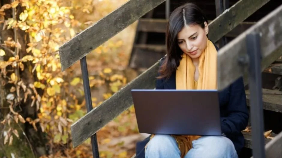 Woman Using Laptop In Autumn Scenery