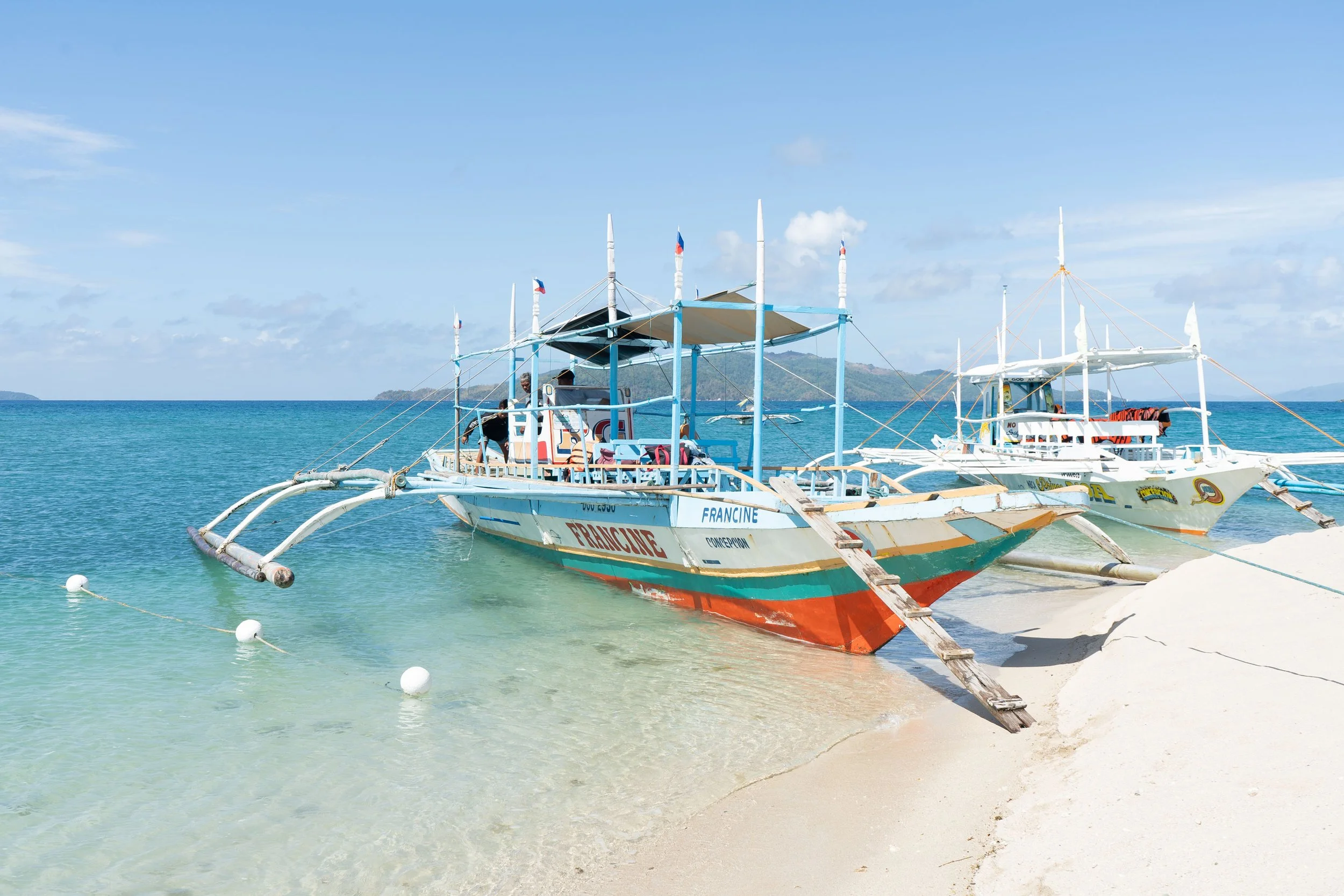 Traditional Filipino boats resting on calm waters, reflecting the deep connection between local communities and the sea in the Philippines.