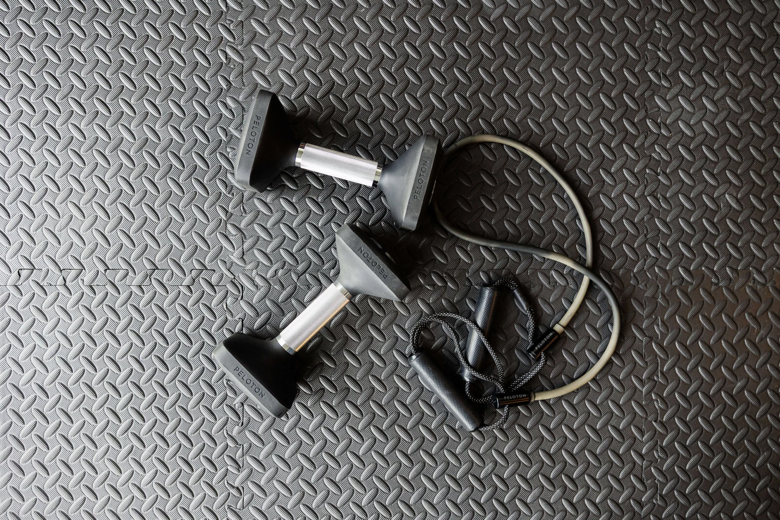 Home gym in garage with black mat and weights. 