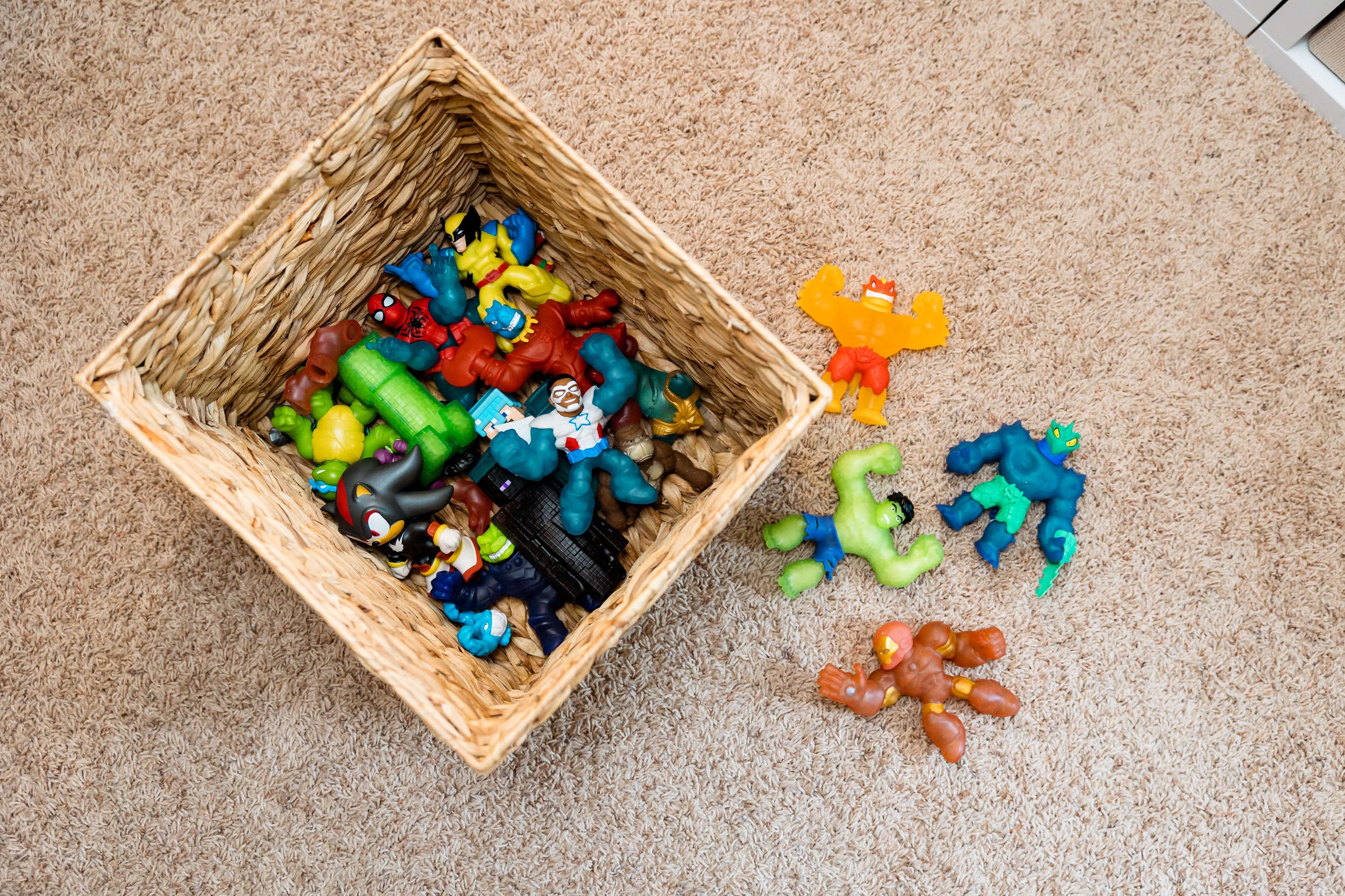 Action figures organized in natural woven storage bin